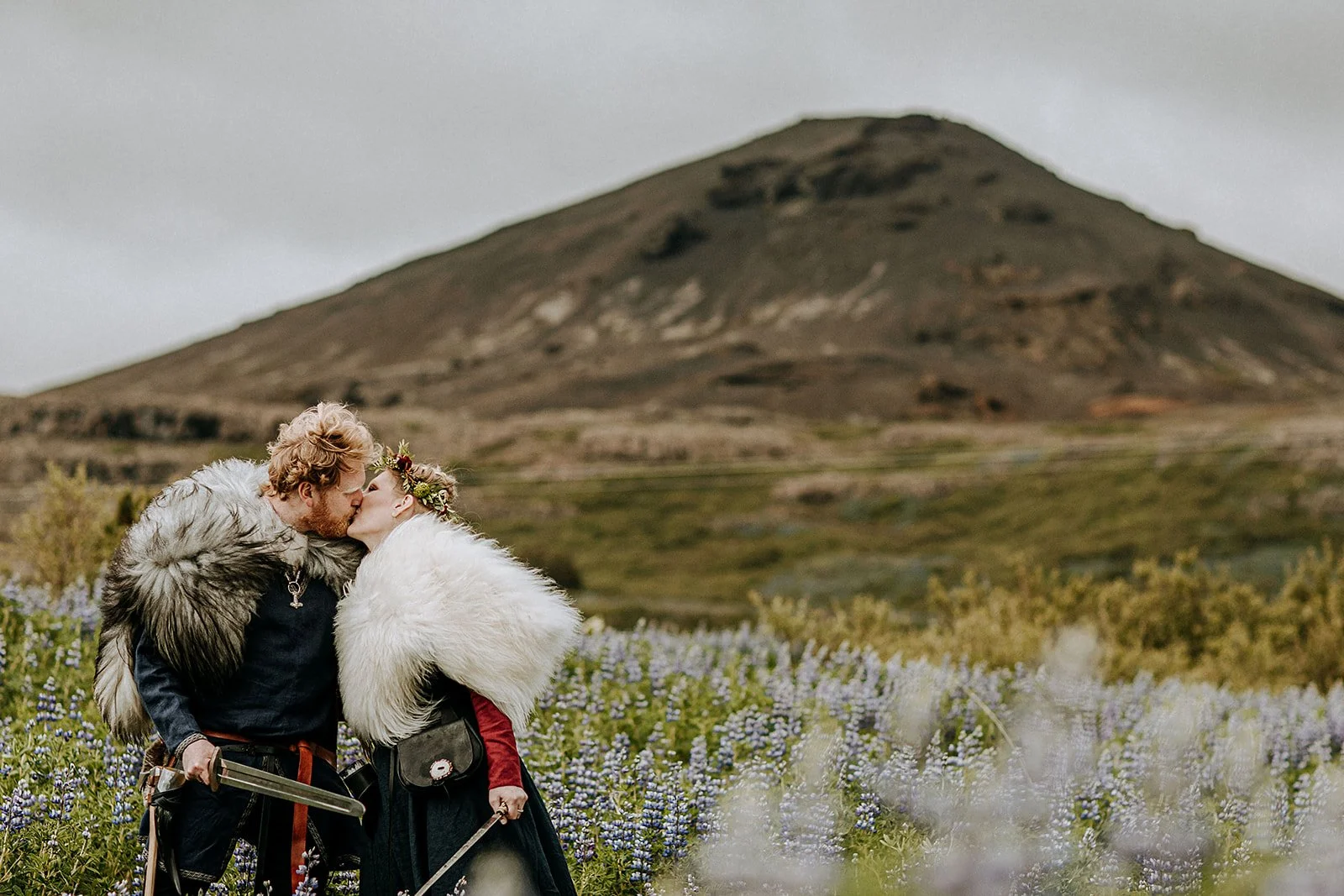 Iceland Viking Elopement with couple in lupine field with swords