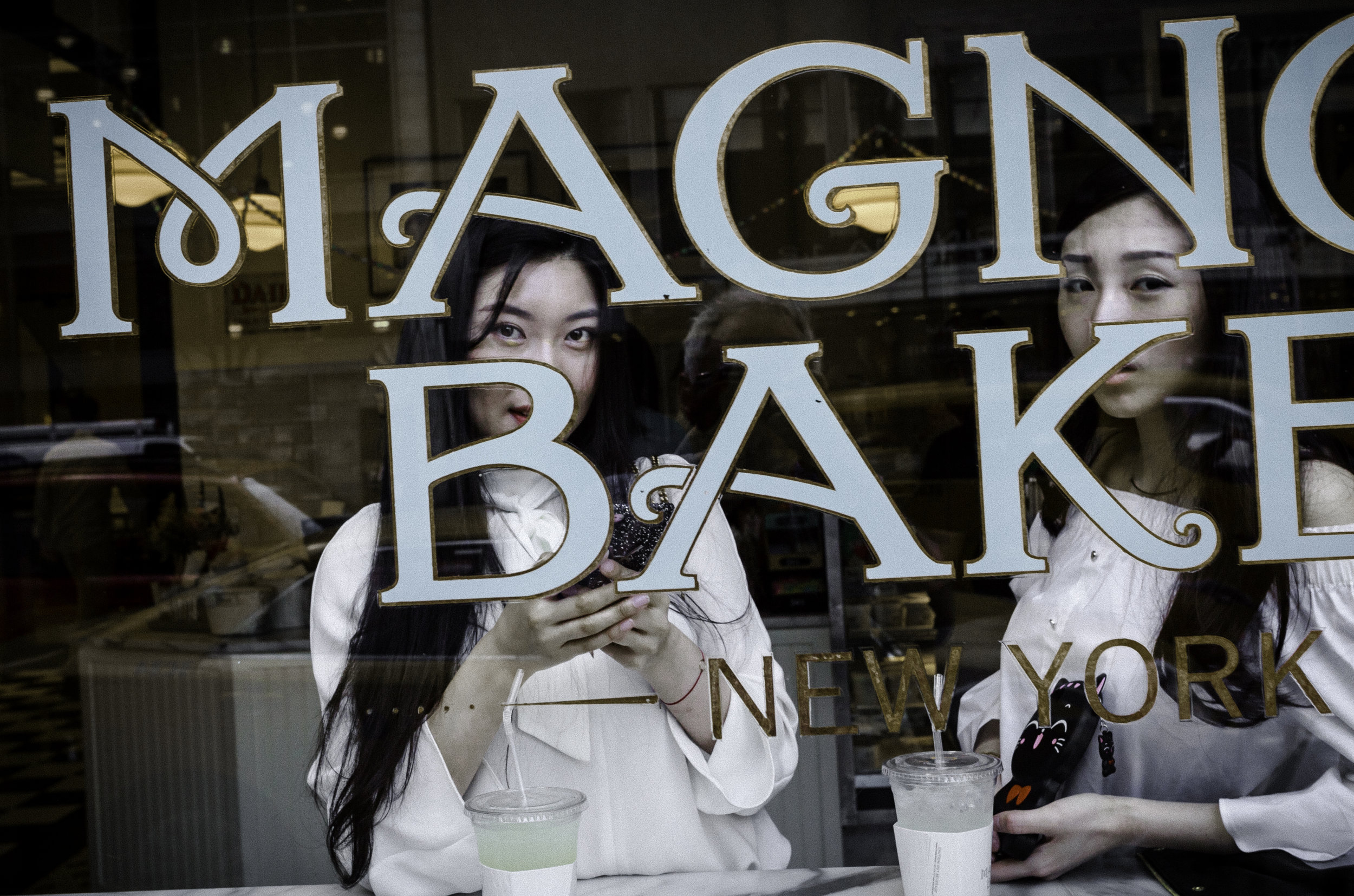 Asian_Women_in_Magnolia_Bakery_Window_57th_St_NYC_2017.jpg