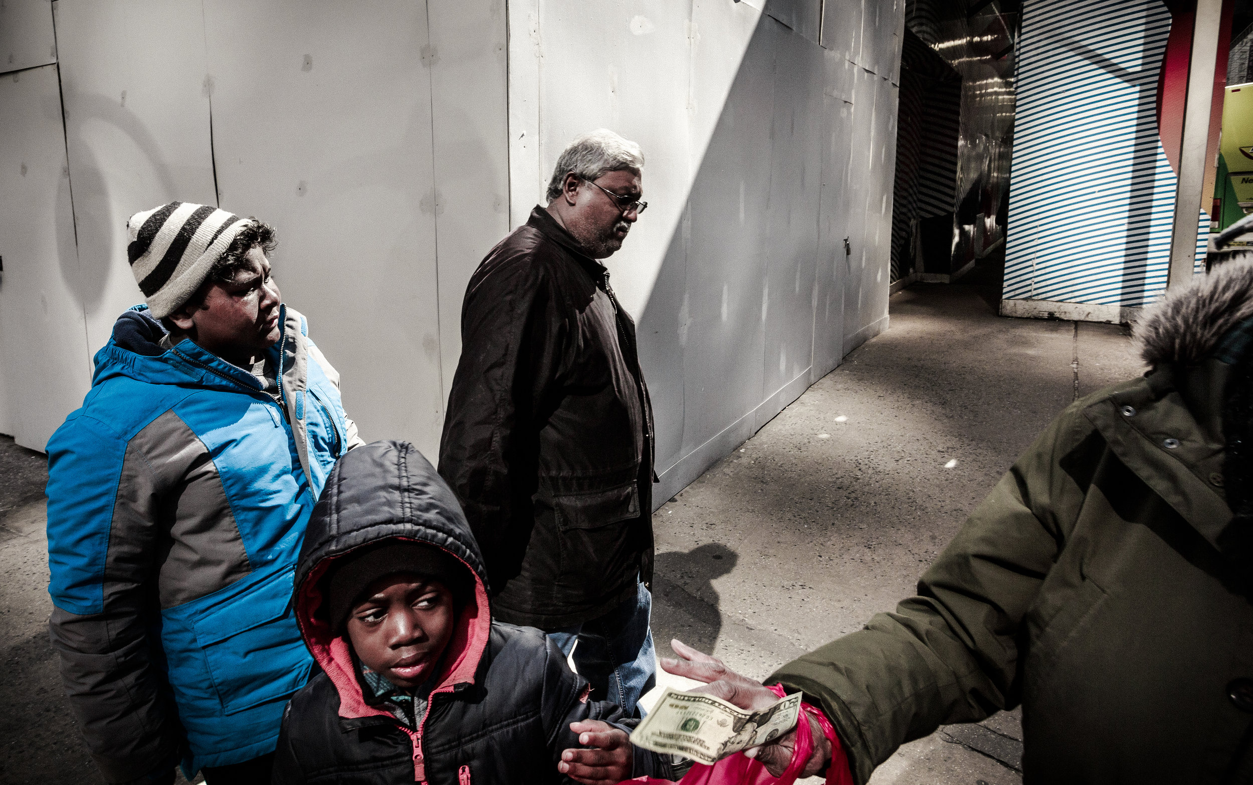 Boy_Being_Handed_Twenty_Dollar_Bill_As_Travelers_Pass_NYC_2017.jpg