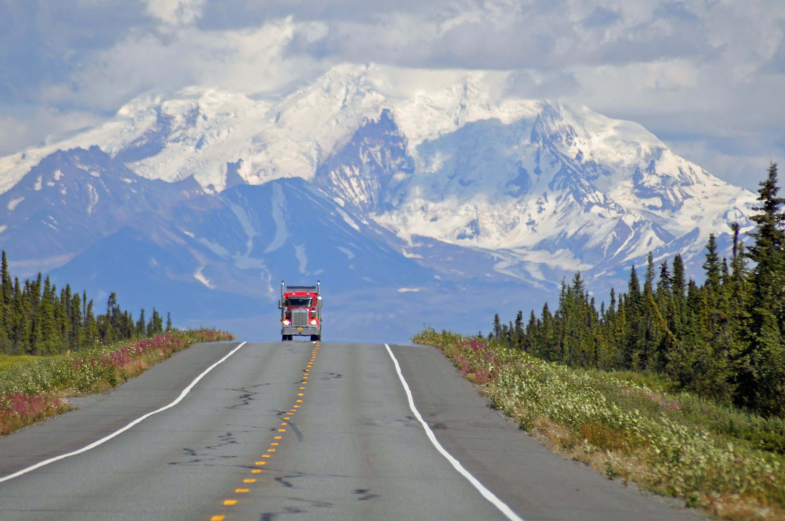  Traveling west on Glenn Highway (Hwy 1), an 18-wheeler is dwarfed by Mt. Drum where it rises in Wrangell-St. Elias National Park and Preserve near Glennallen AK. 