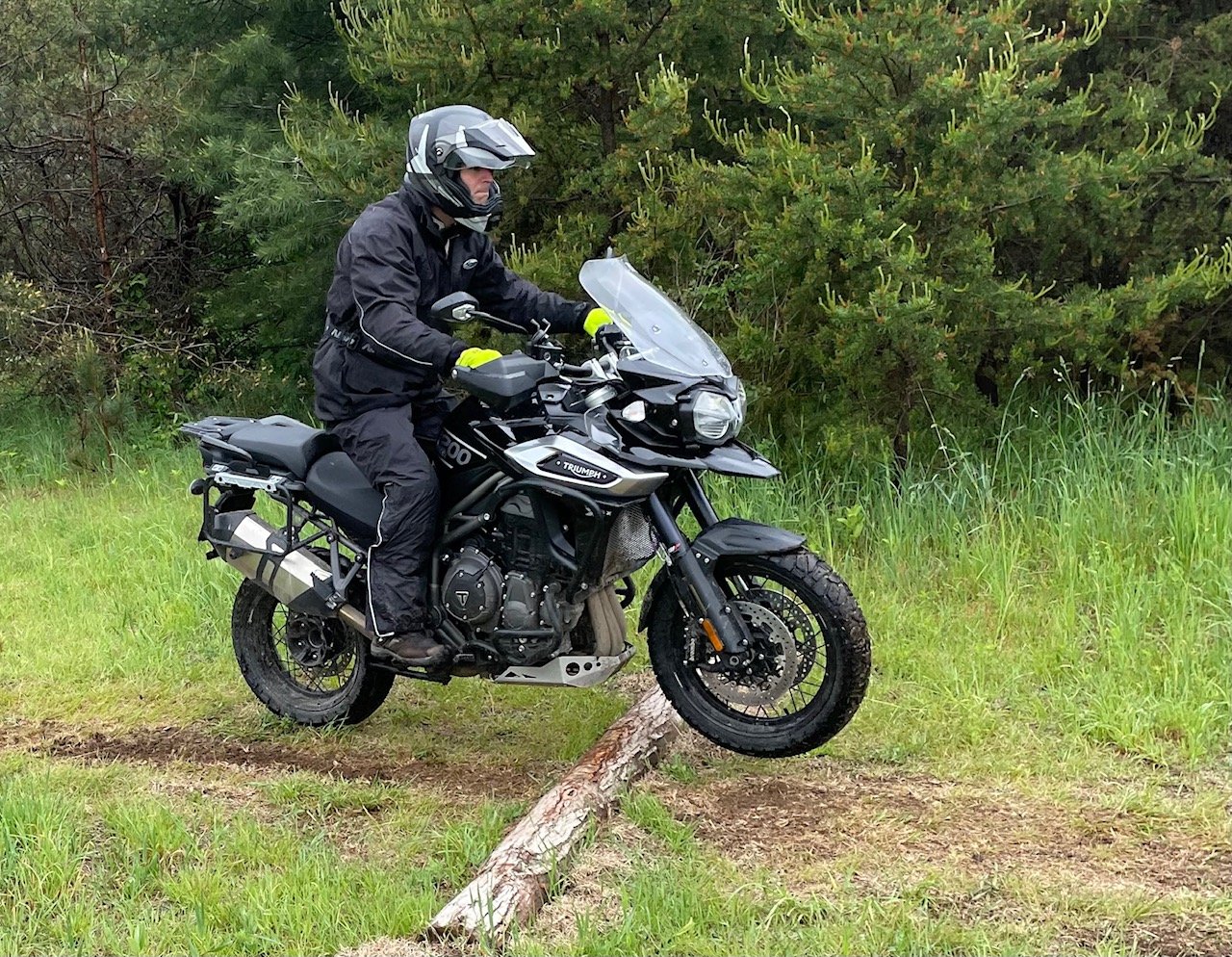 Motorcycle riding over a small log.