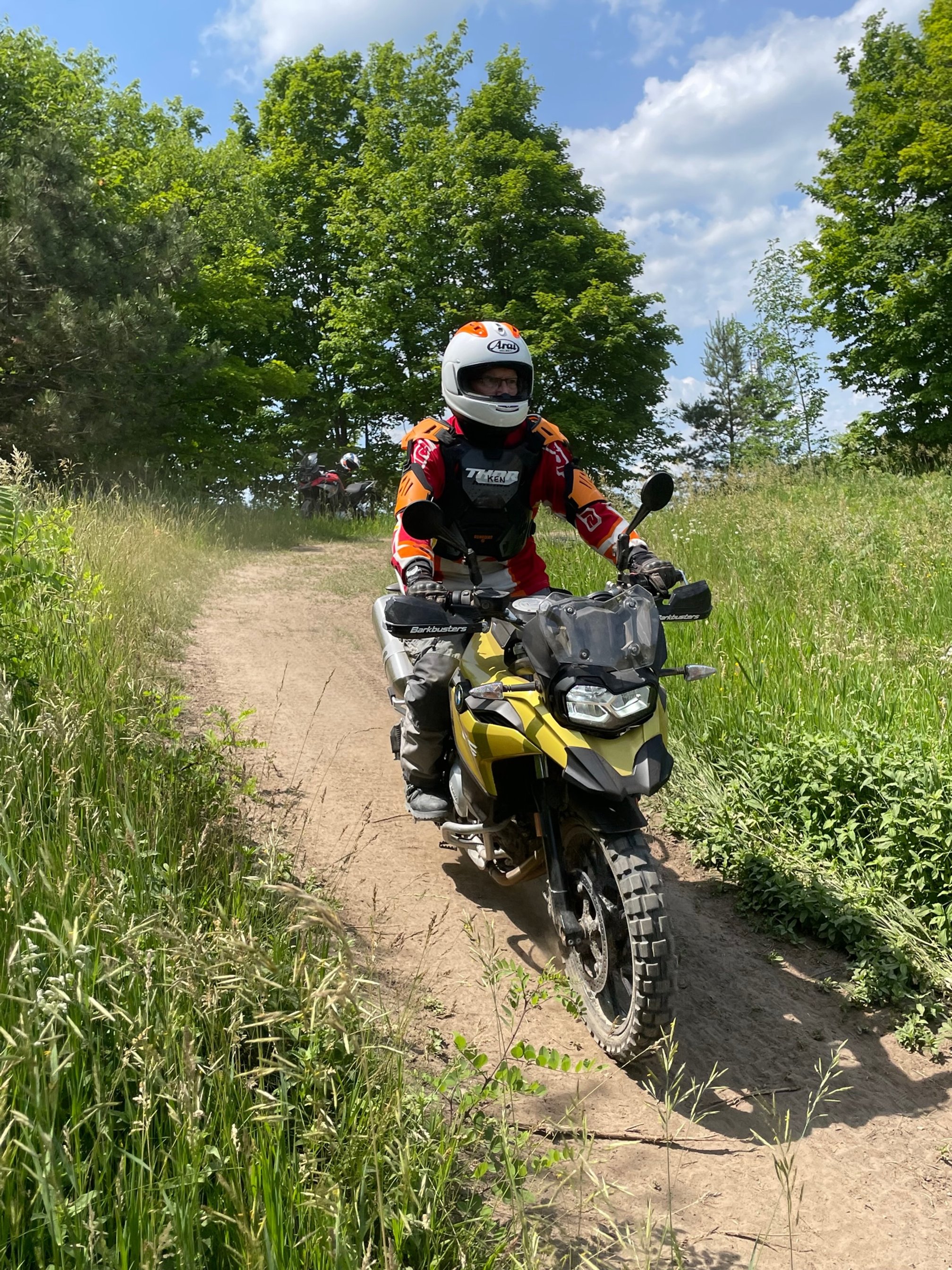 Adventure motorcycle riding on a rough dirt trail.