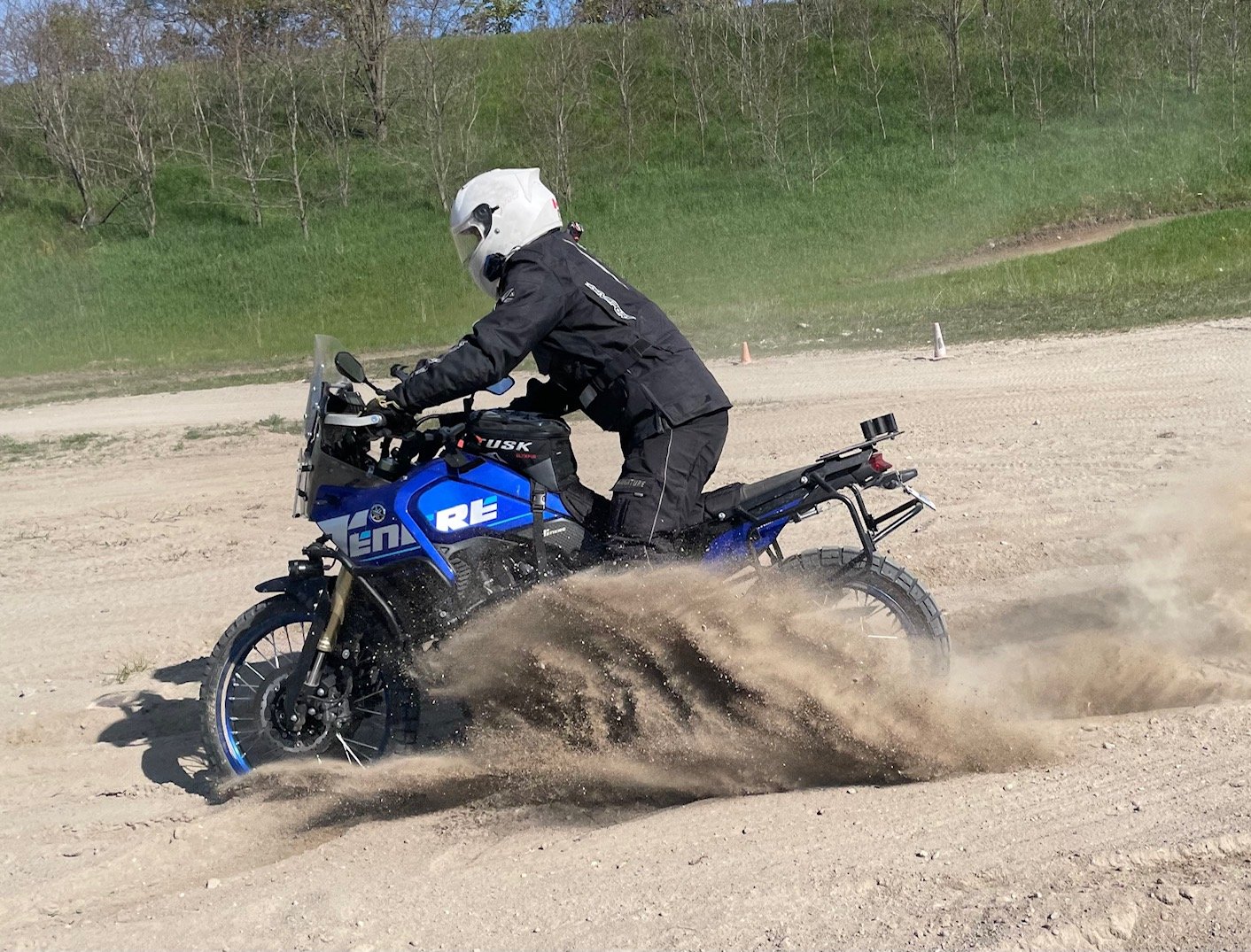  Motorcycle spinning front tire in sandy dirt. 