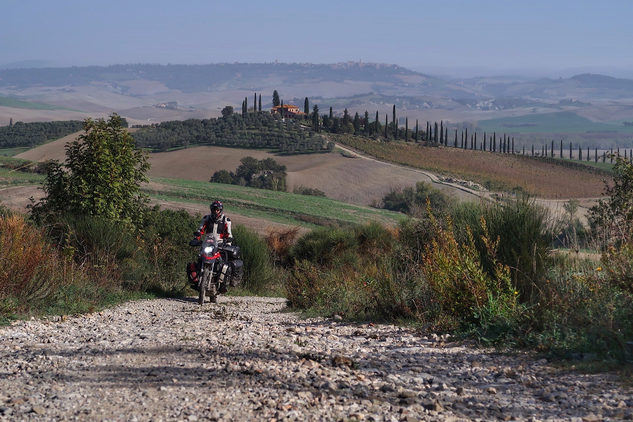  Motorcycle on trail overlooking European village. 