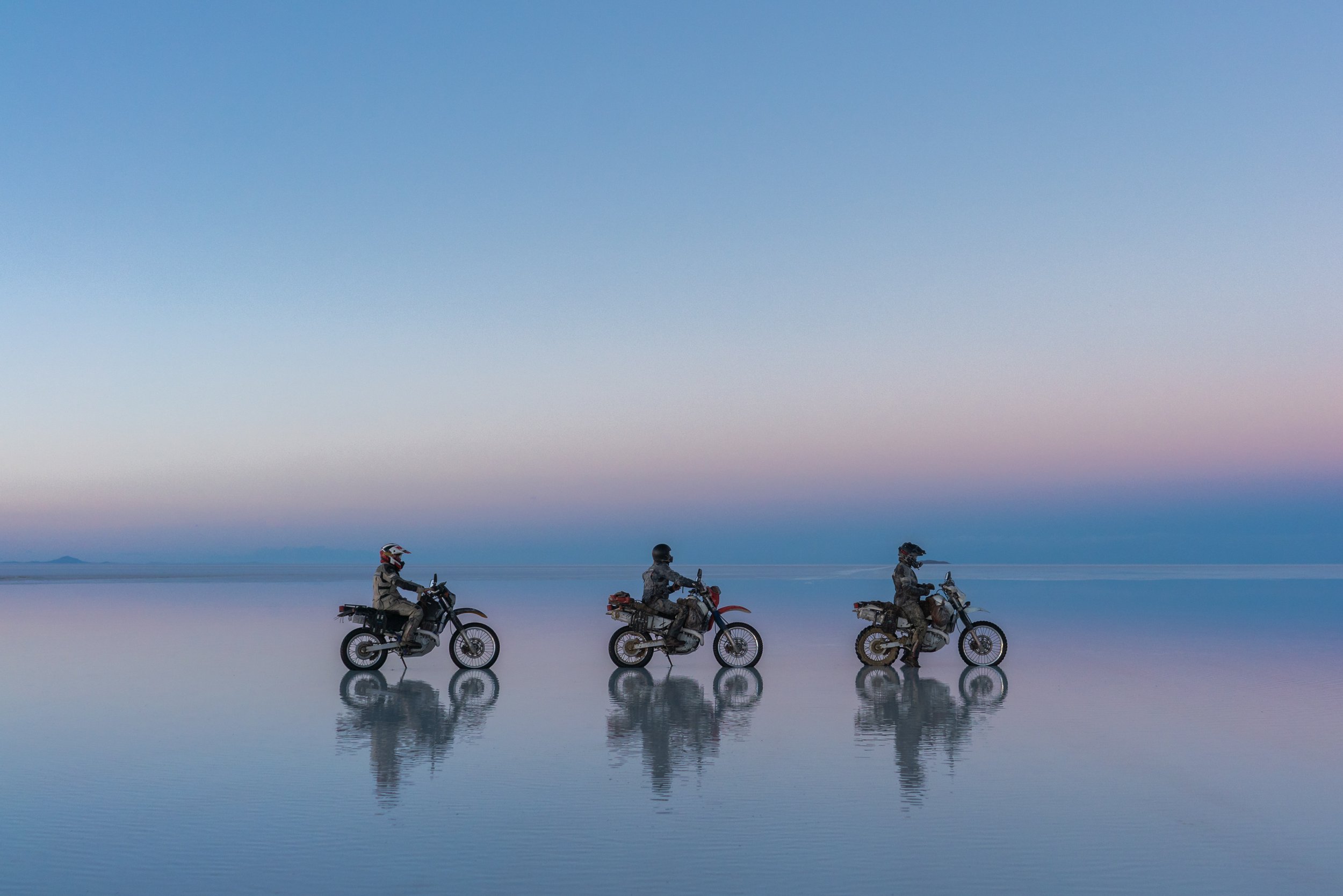  Three motorcycles on a water lake surface. 