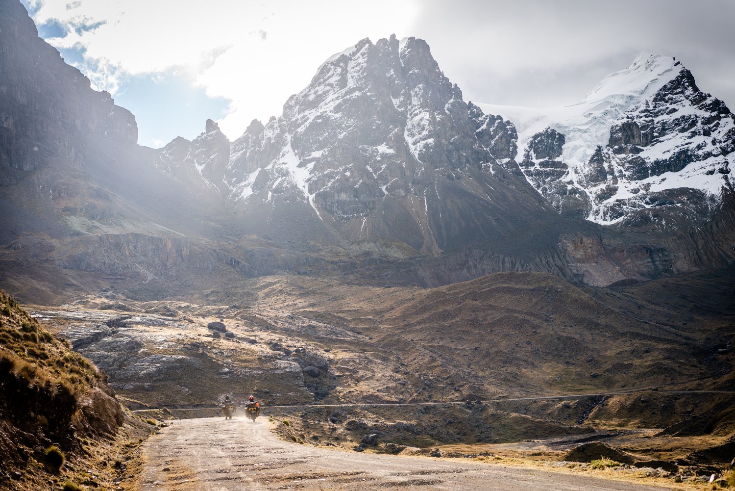  Two motorcycles riding along a mountain trail. 