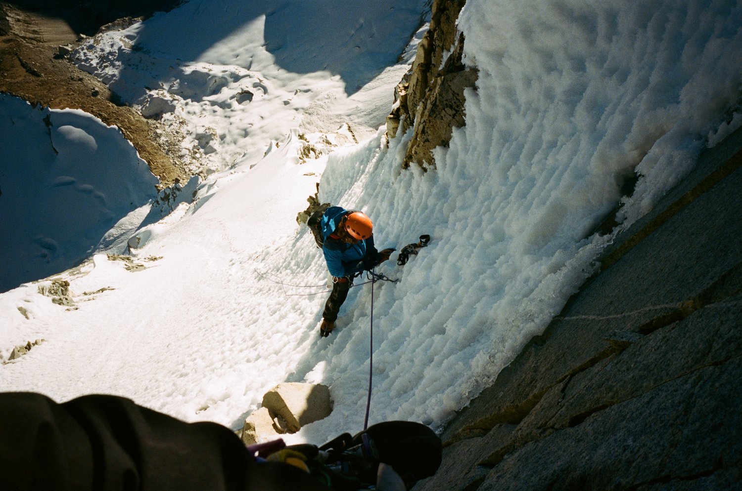  Mountain climber climbing snow covered mountain. 