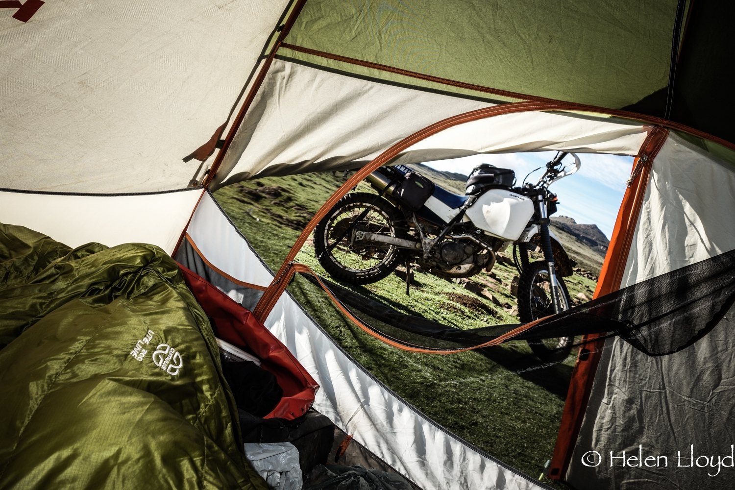 View from inside tent looking out at motorcycle. 