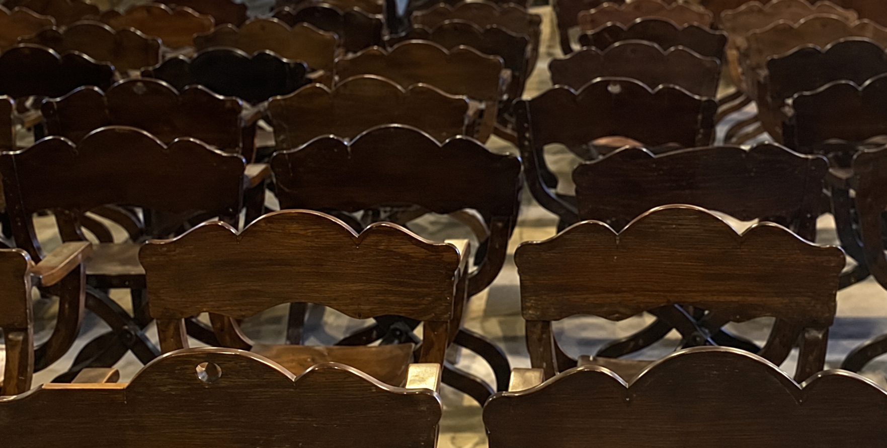 Rows of dark wooden chairs.png