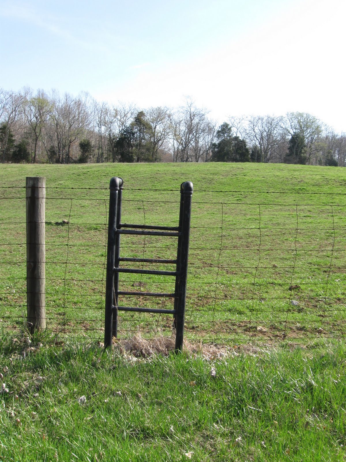 Here, steel plumbing pipe is co-opted into service as a stile for scaling a wire fence.
