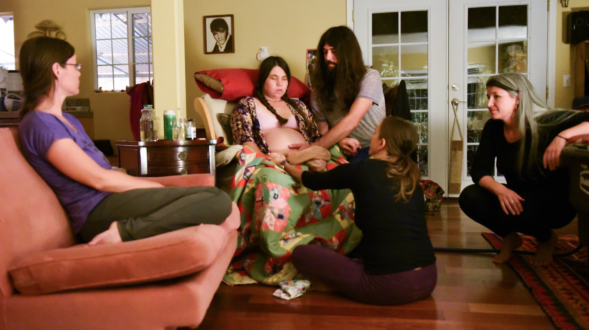 Midwife Kathy on the little couch, Owen's hand keeping my contracting womb warm, midwife Cindy pressing on my thighs to help alleviate the pain, and JenJen.