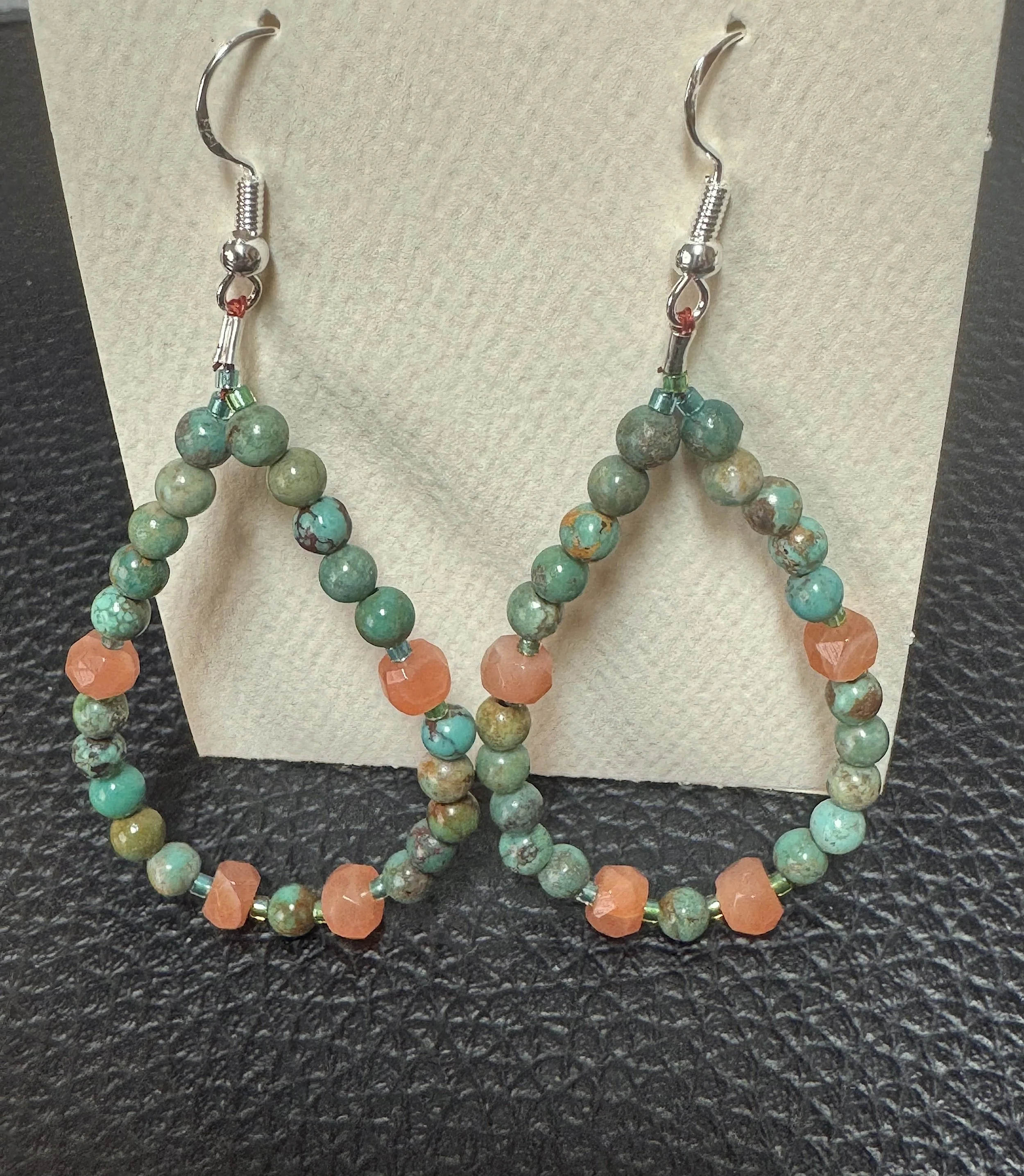 Turquoise and Rainbow Moonstone hoops on stand.jpeg