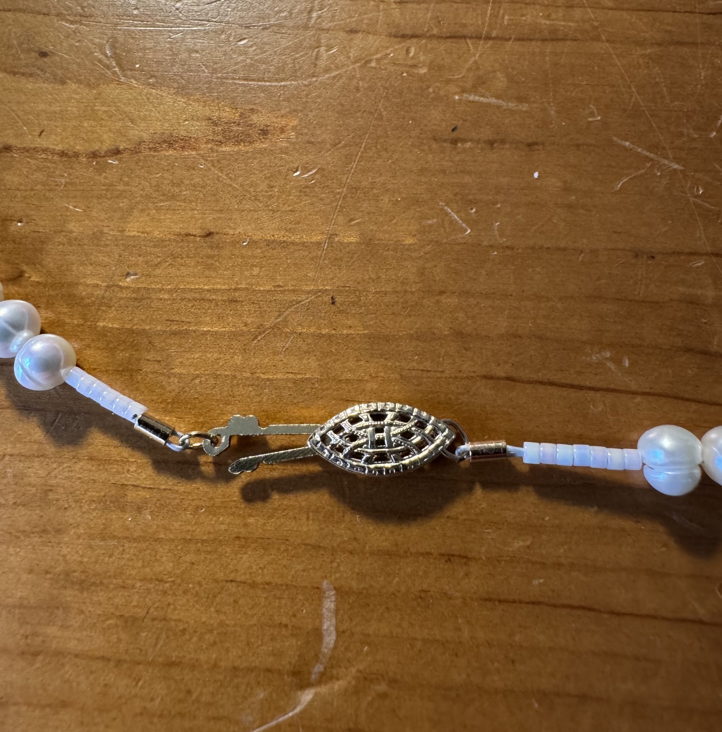 Cultured white pearls with gold clasp partly closed.jpg