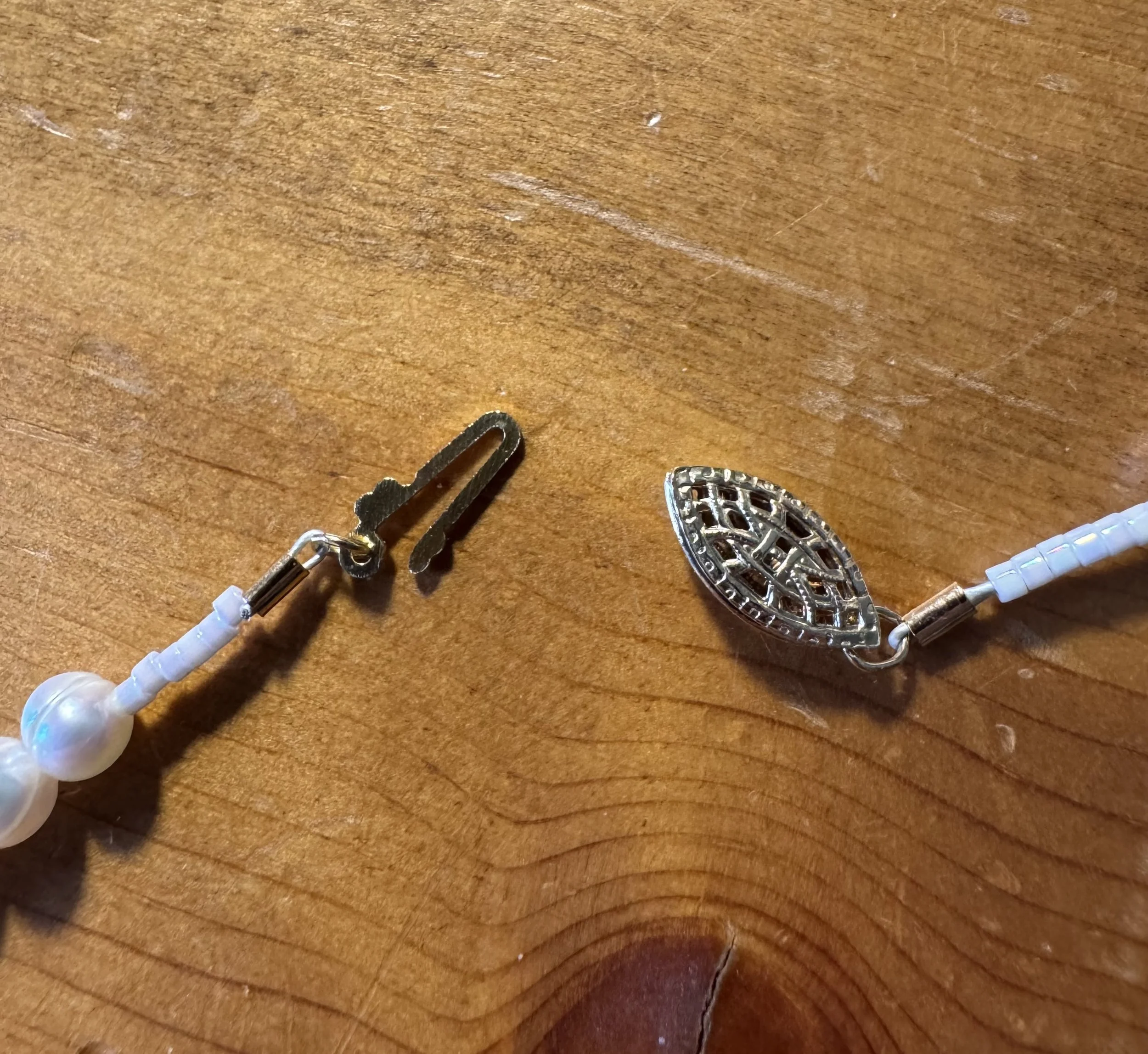 Cultured white pearls with gold clasp open.jpg