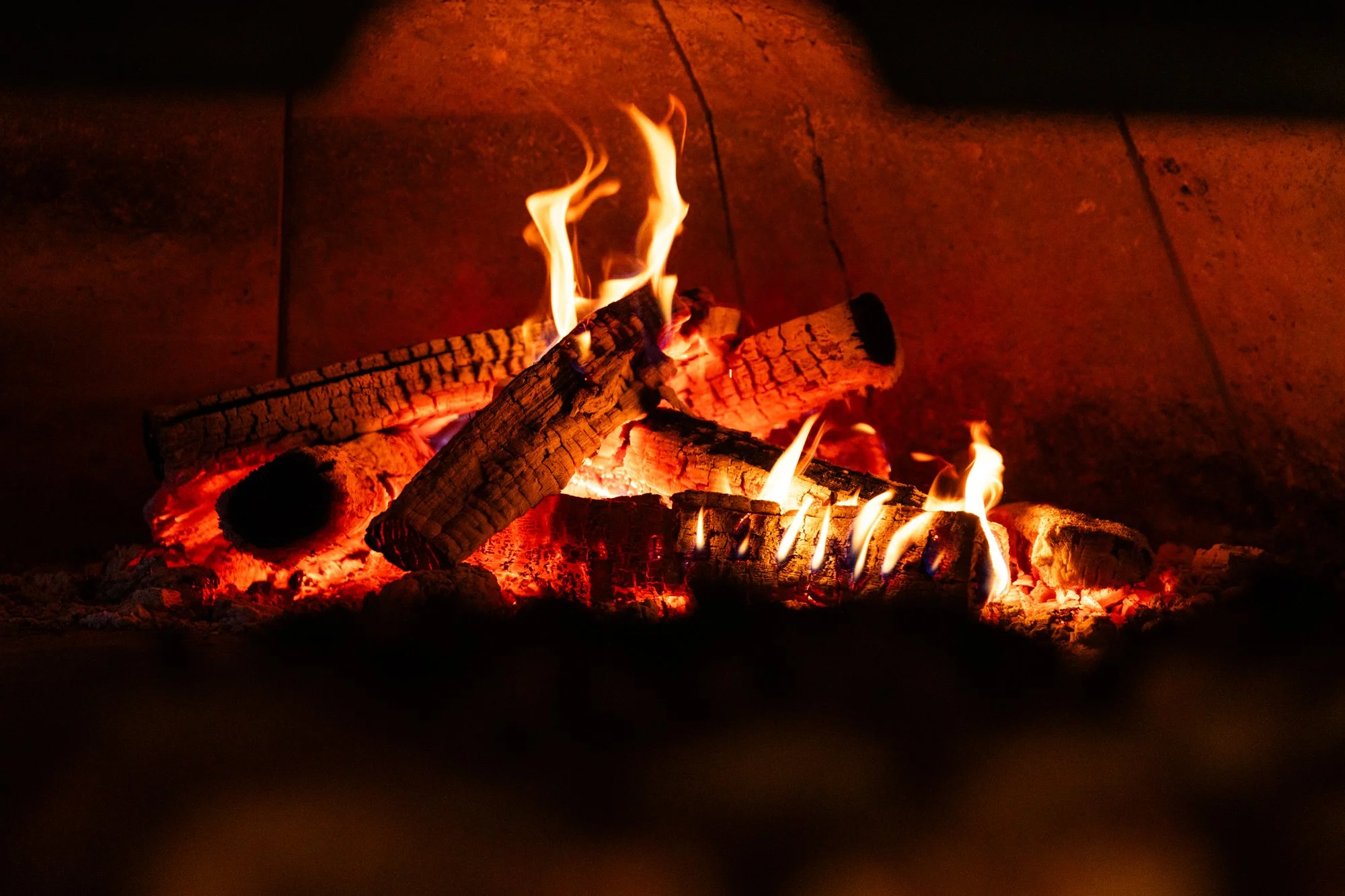 Fire burning logs in a fireplace. Ovenbird Restaurant in Birmingham, Alabama.