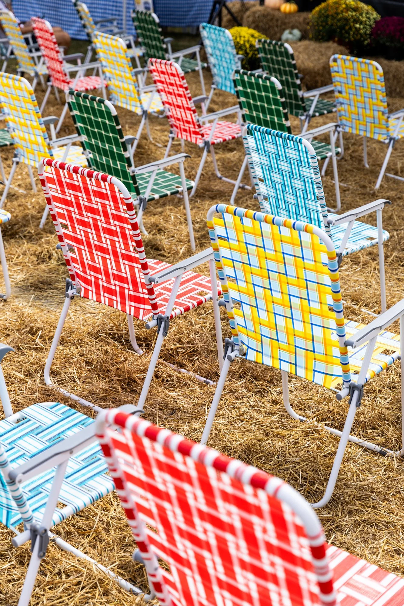 Multiple colorful plaid patterned lawn chairs arranged on straw-covered ground at an outdoor event. Southbound Food Festival in Birmingham, Alabama.