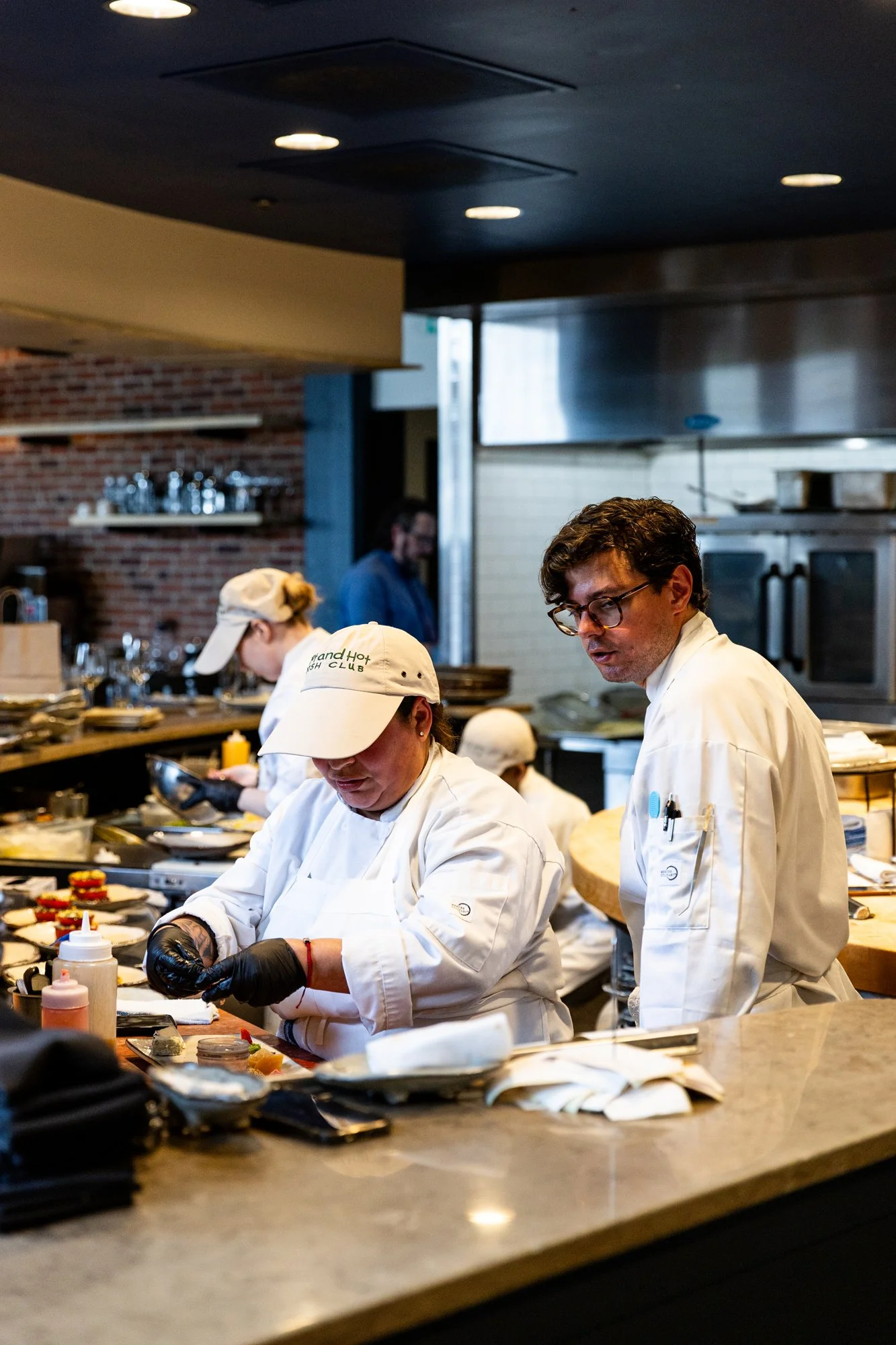 Chefs preparing food in a professional kitchen. Hot andHot Fish Club Restaurant in Birmingham, Alabama.