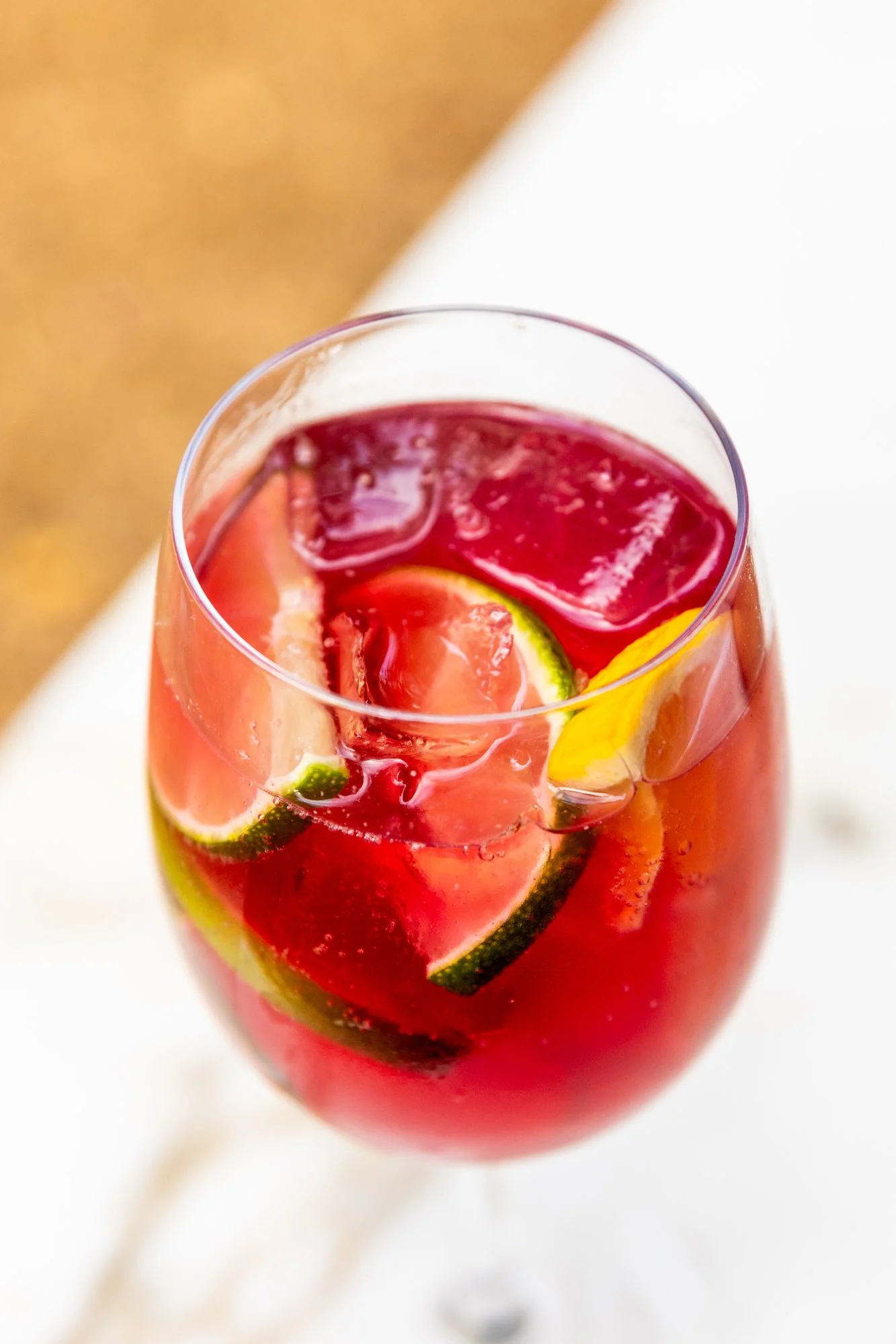 A glass of sangria containing slices of lime, lemon, and orange with ice cubes. Ovenbird Restaurant in Birmingham, Alabama.