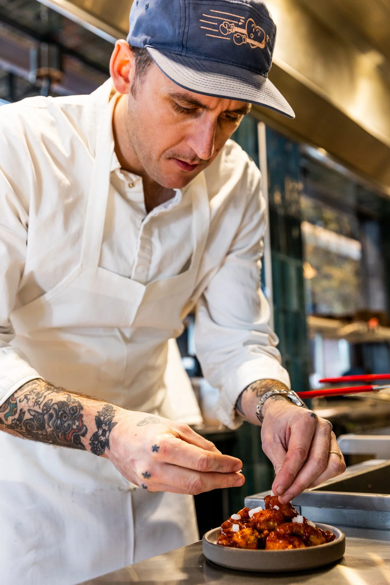 Chef garnishing a plate of food in a professional kitchen