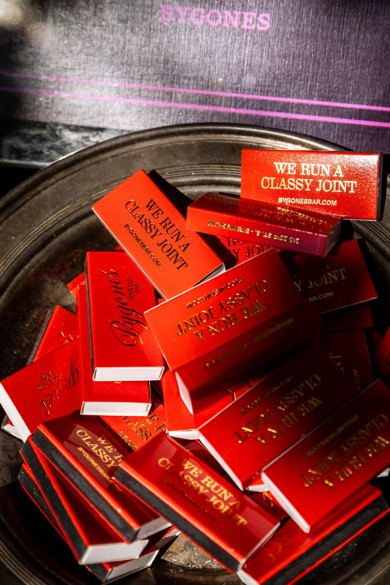 Multiple red matchboxes labeled 'WE RUN A CLASSY JOINT' with gold text, placed in a black bowl. Southbound Food Festival in Birmingham, Alabama.