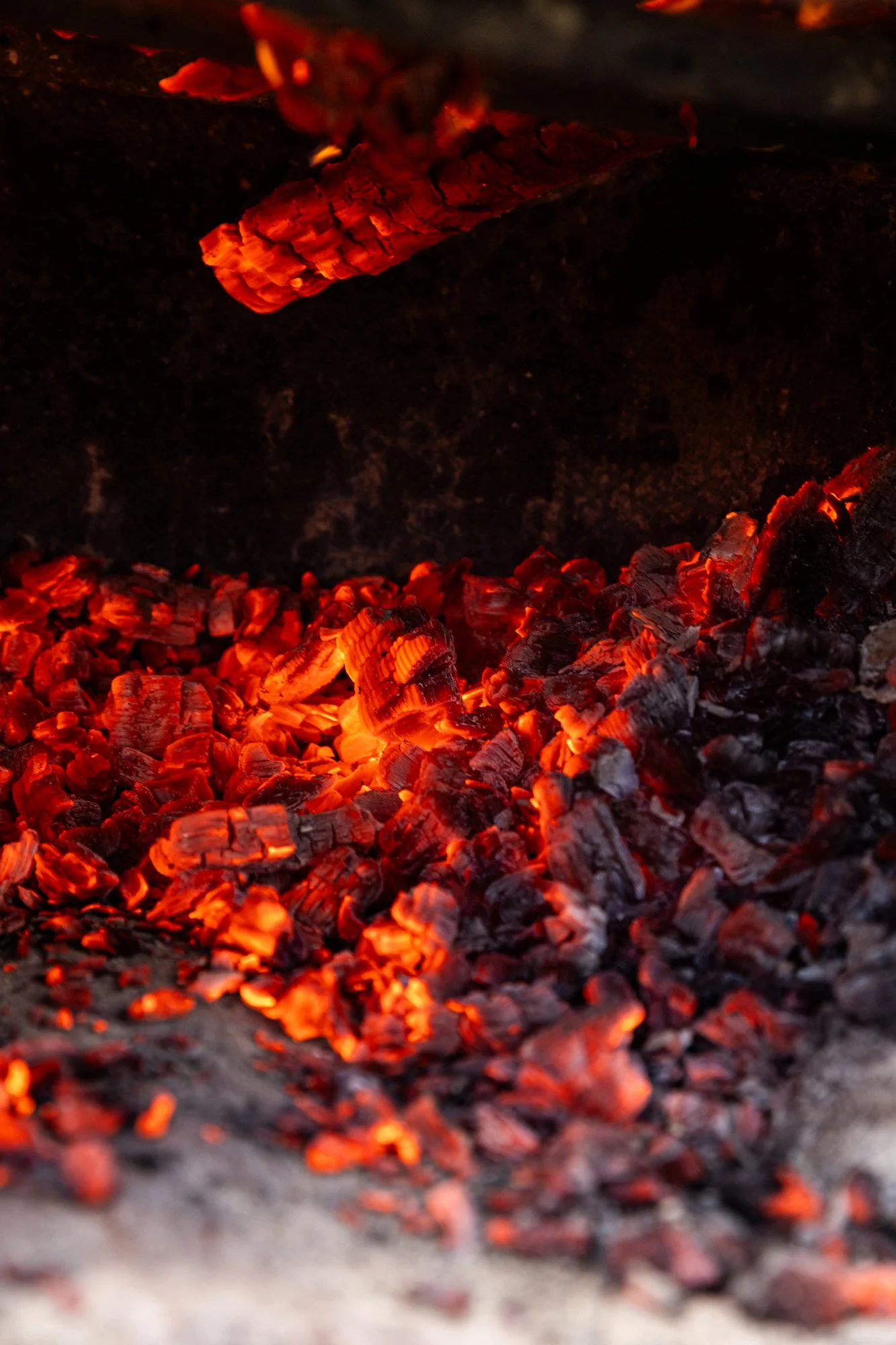 Close-up of burning red and orange hot embers inside a fireplace or fire pit. Southbound Food Festival in Birmingham, Alabama.