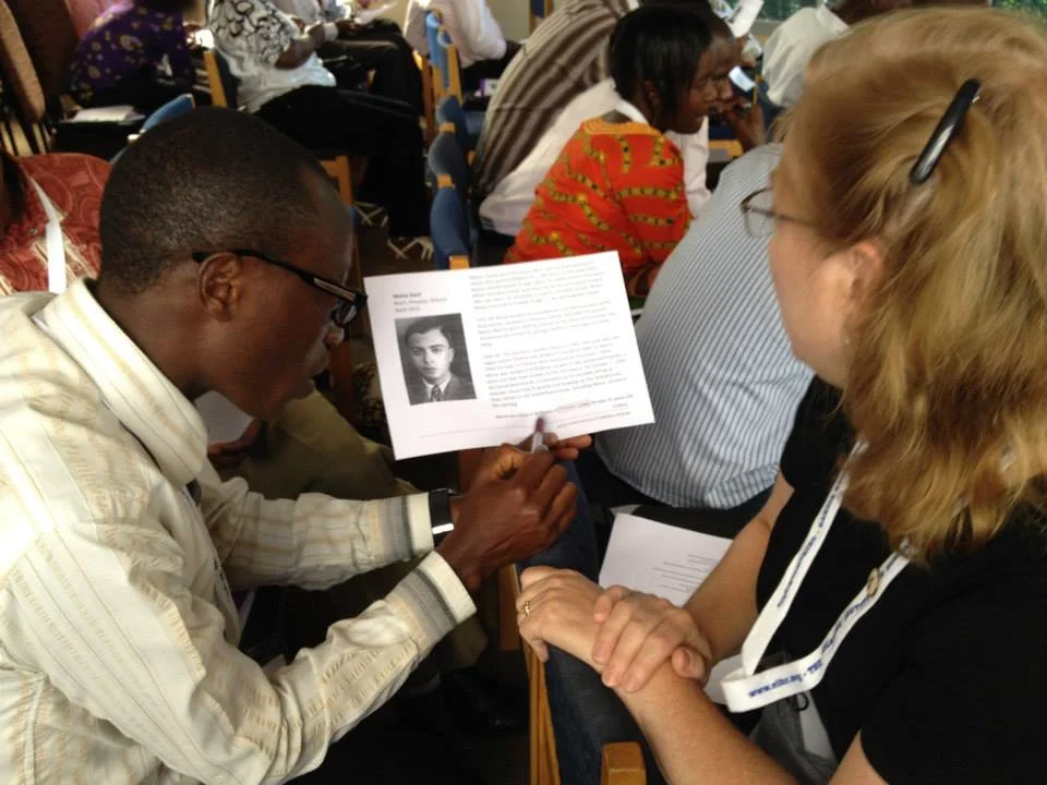 21-A partner teacher clarifies information from a USHMM ID card to prepare to place it on the timeline — at Rwanda-Kigali.jpg