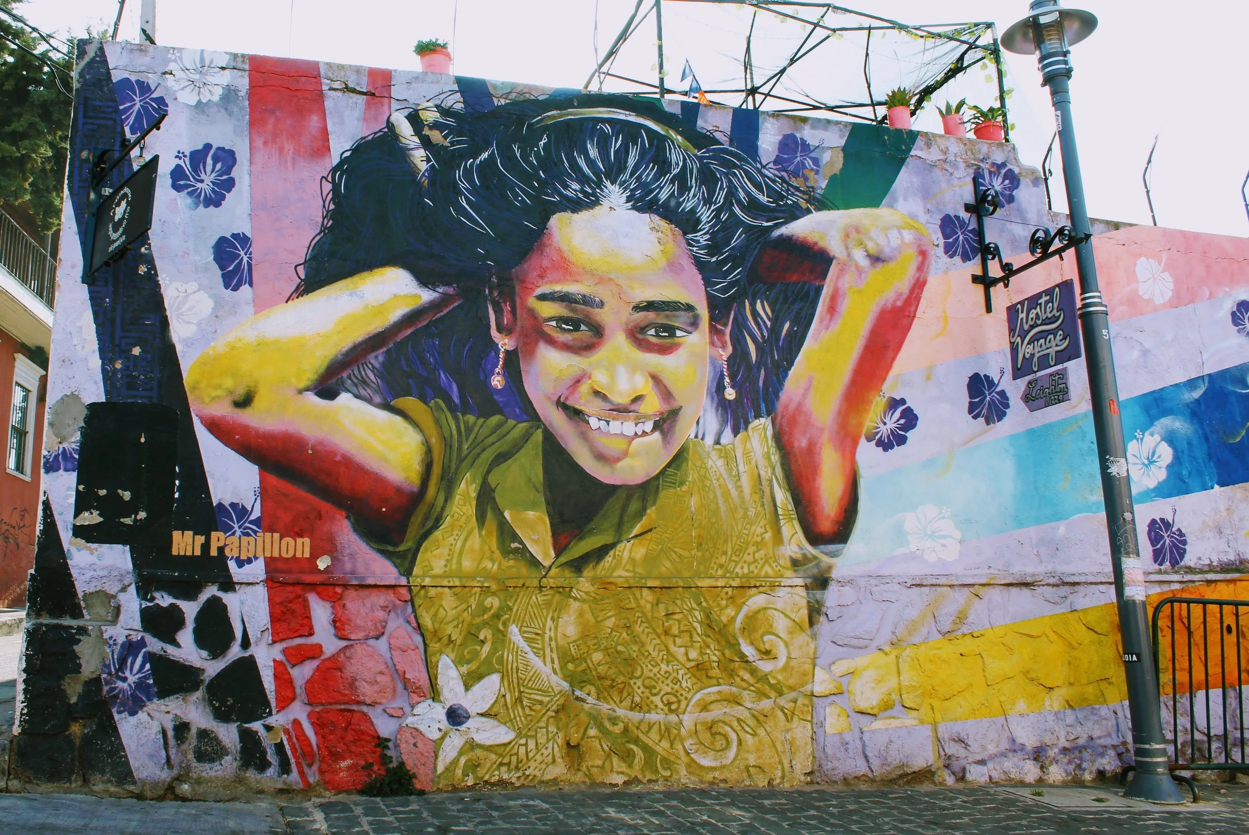 Street art mural of "Young Girl" by Mr Papillon for Hostal Voyage