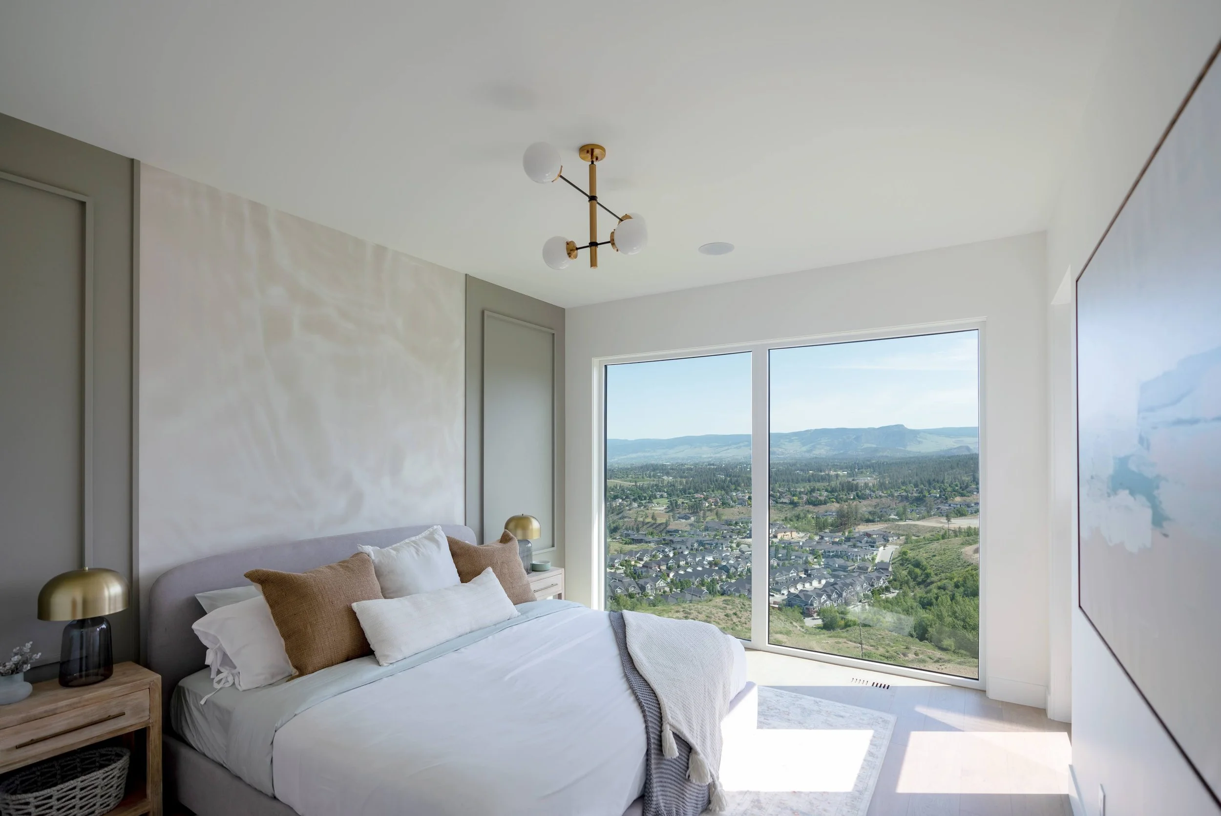 Primary bedroom with floor-to-ceiling windows and valley views, Trailhead Showhome, Kelowna