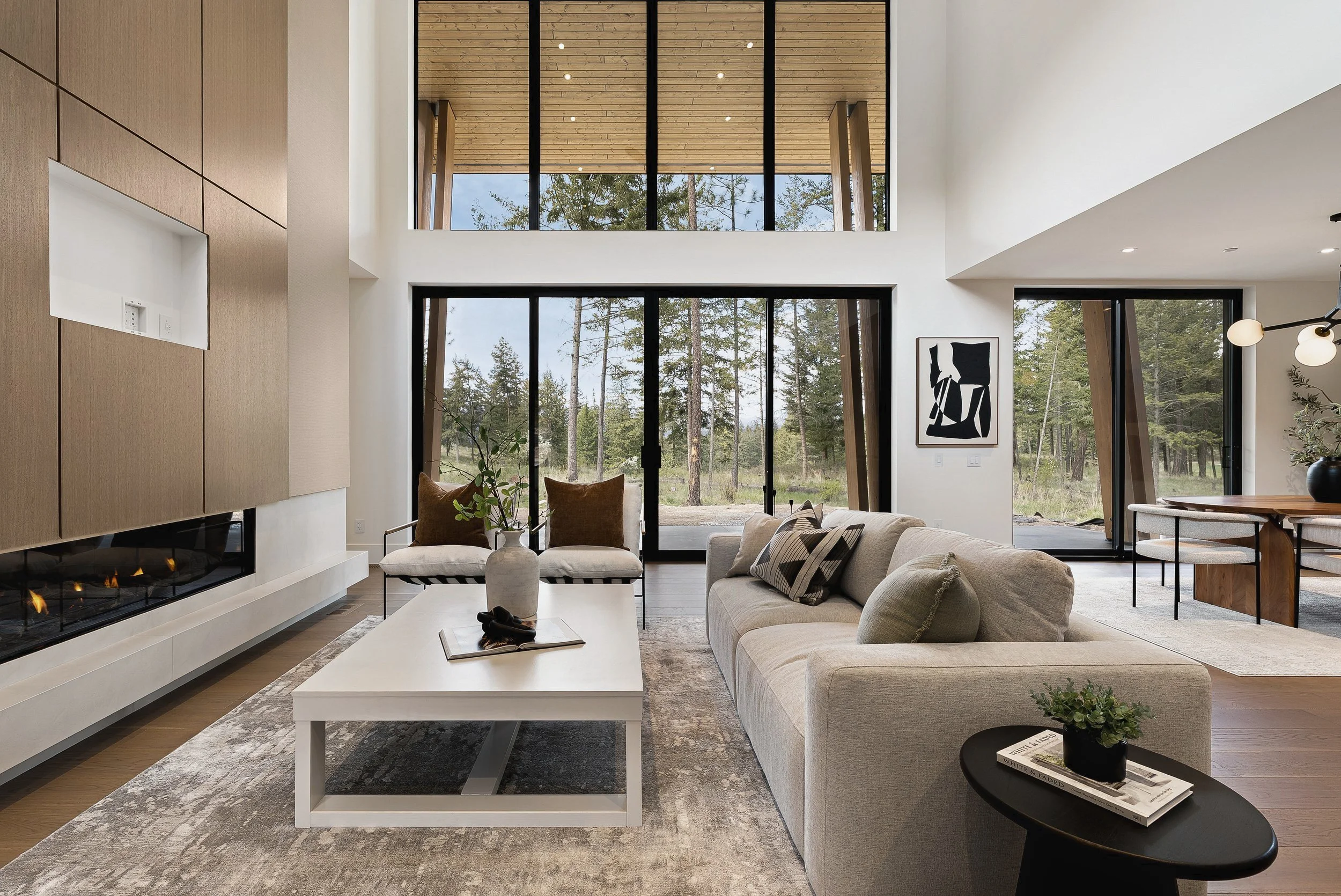 Living area with a linear fireplace and tall windows, Green View Residence, Predator Ridge
