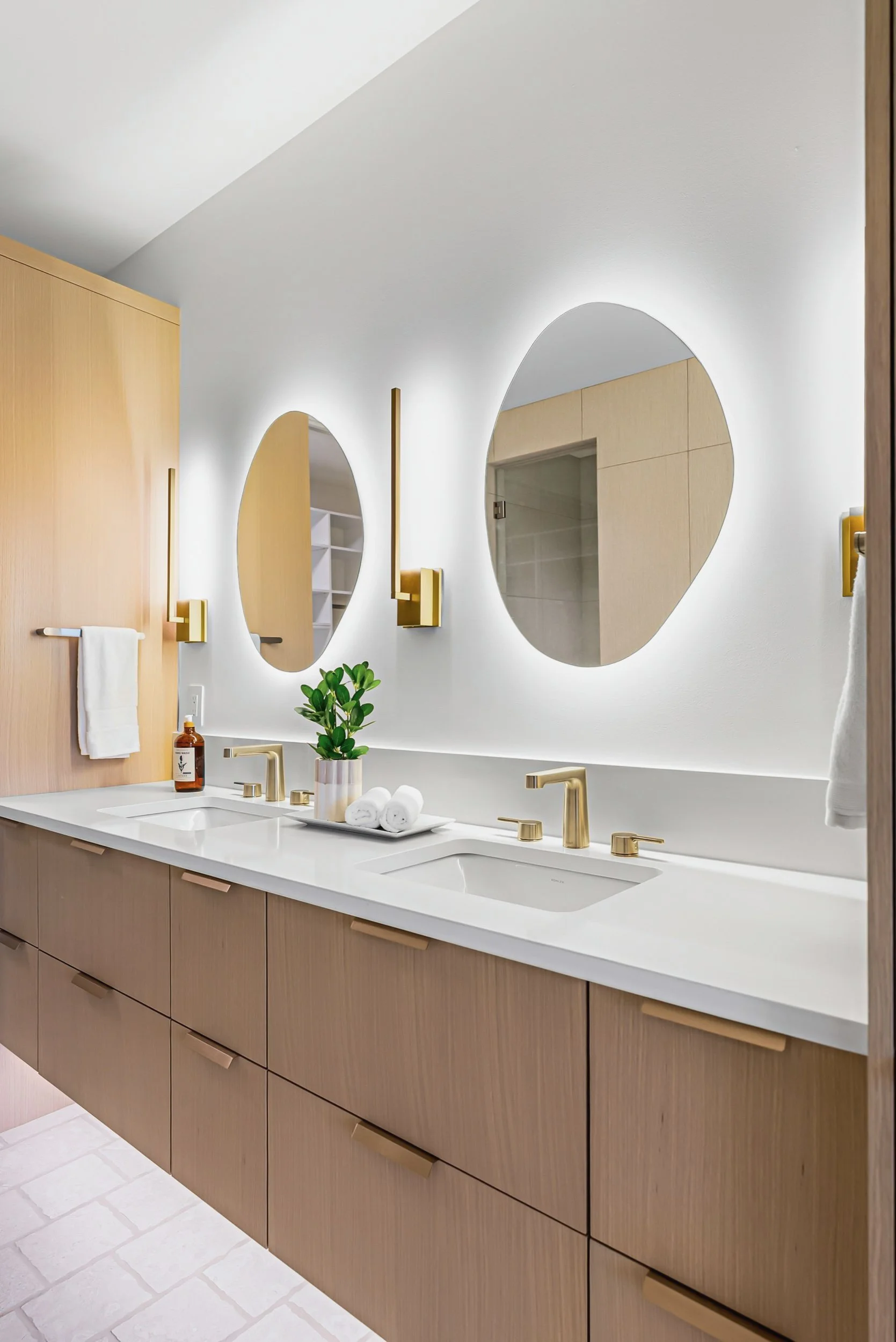 Double vanity with oval backlit mirrors and brass fixtures, Ellison Walkout, Predator Ridge