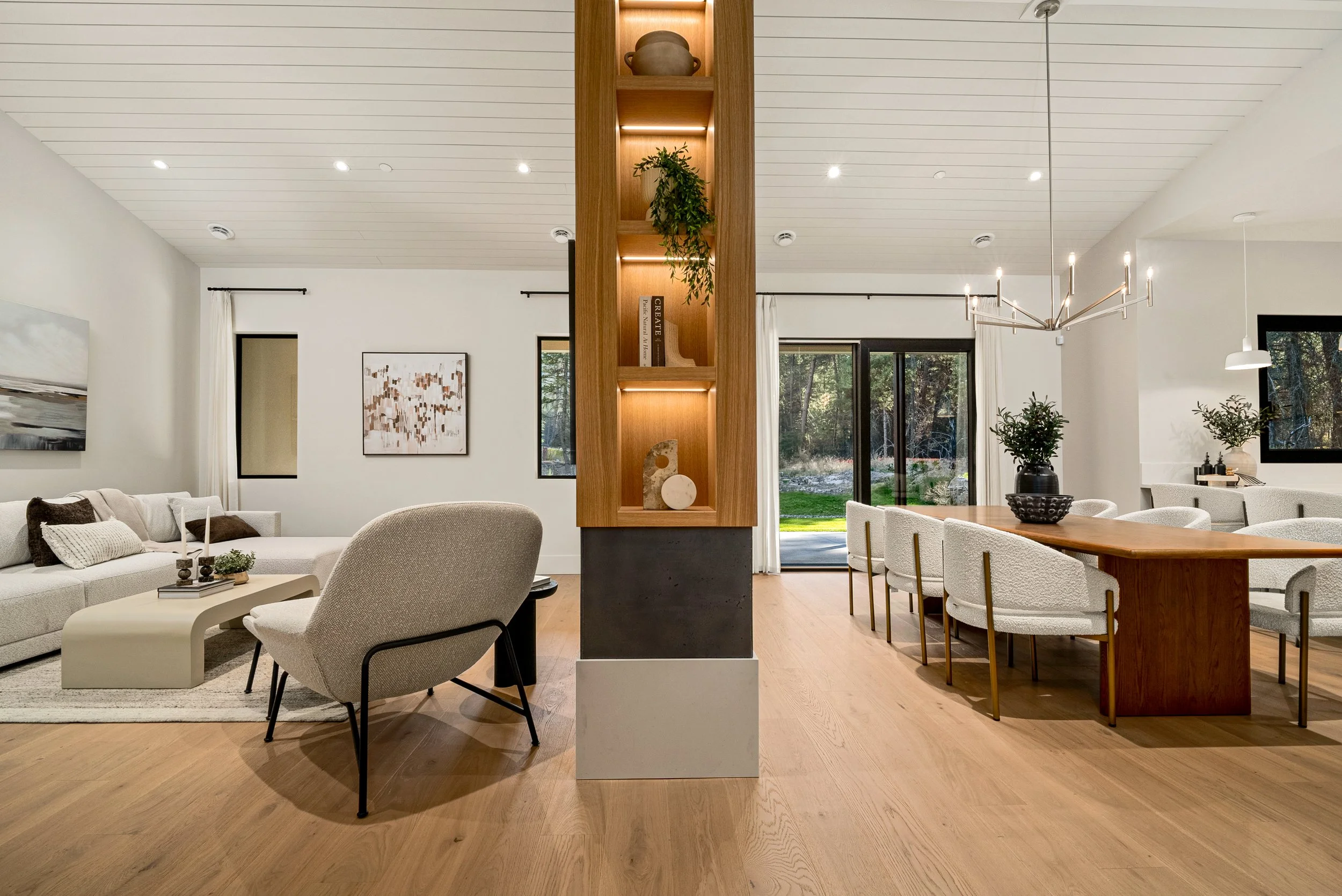 Woodside Showhome great room with a lit wood shelving column between the living area and the dining table