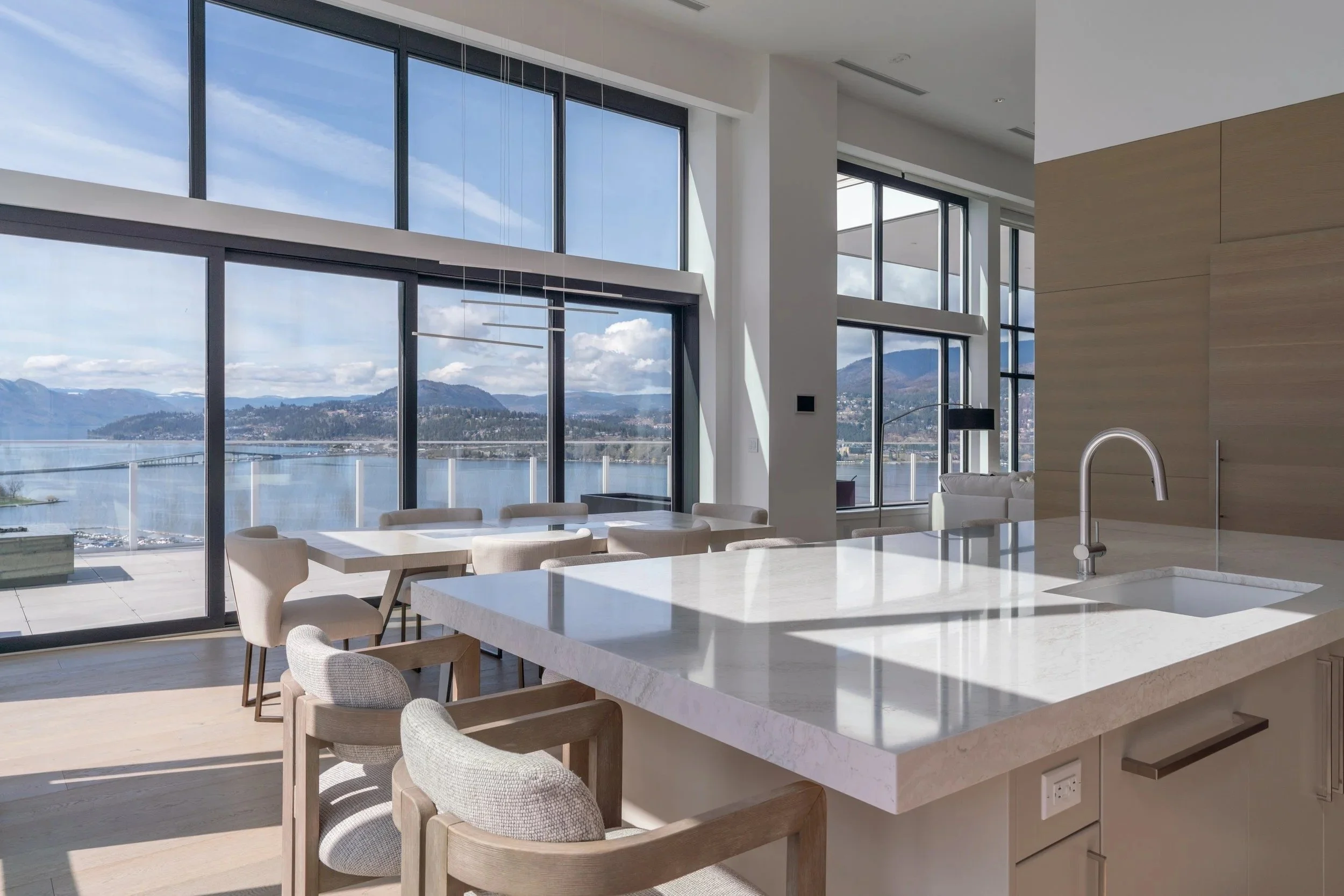 Penthouse kitchen and dining room with floor-to-ceiling glass over Okanagan Lake, One Water Street, Kelowna