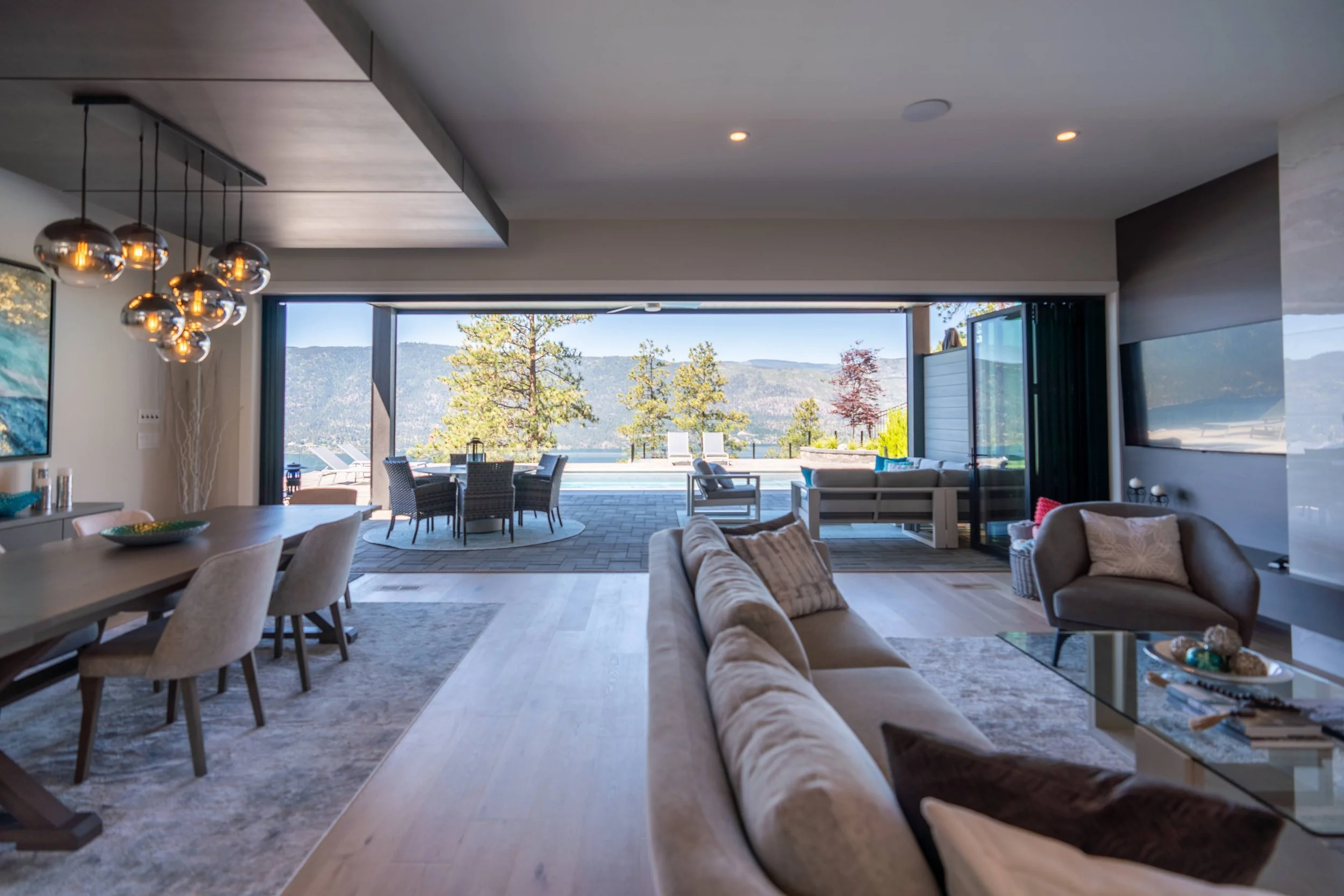 Great room with glass pendants over the dining table and folding glass walls to the deck, Beacon Hill, Lake Country