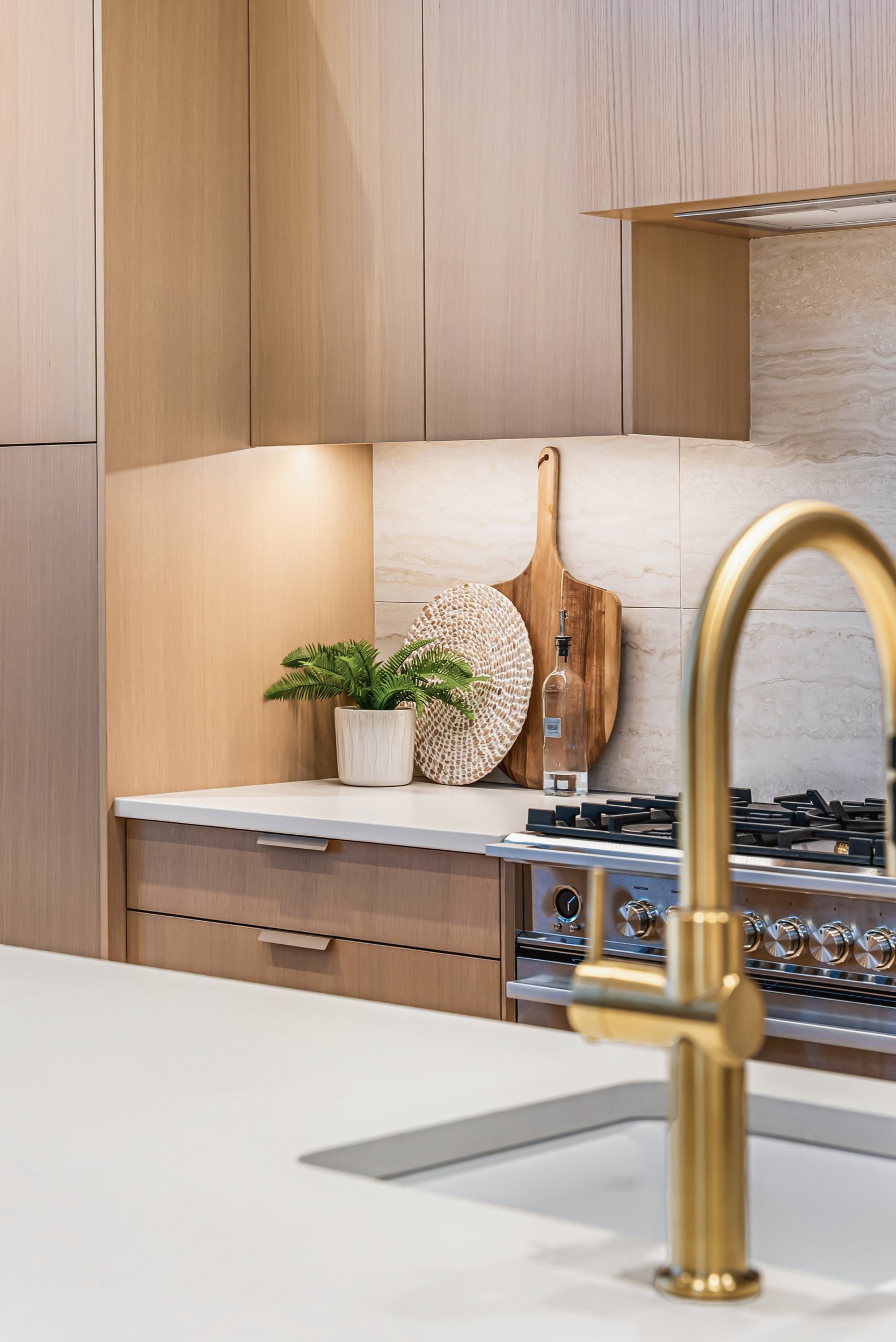 Brass kitchen faucet with oak cabinetry and the range behind, Ellison Walkout, Predator Ridge