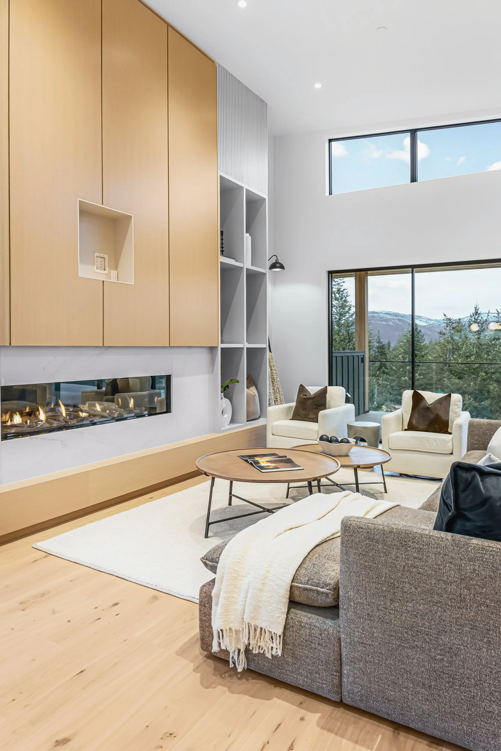 Living area beside the oak fireplace wall, with windows to the trees, Ellison Walkout, Predator Ridge