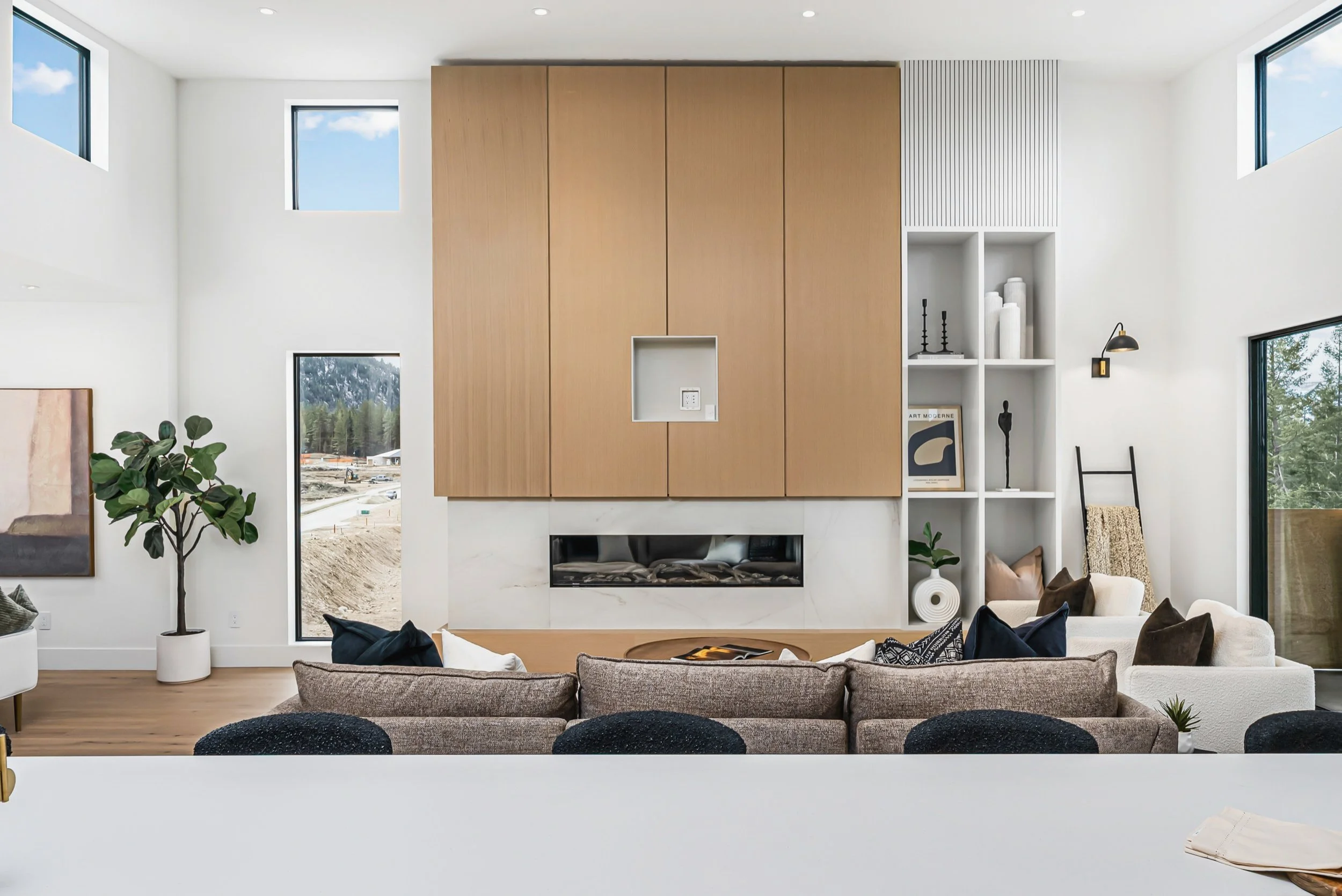 Light oak fireplace wall with a linear fireplace and open shelving under clerestory windows, Ellison Walkout, Predator Ridge