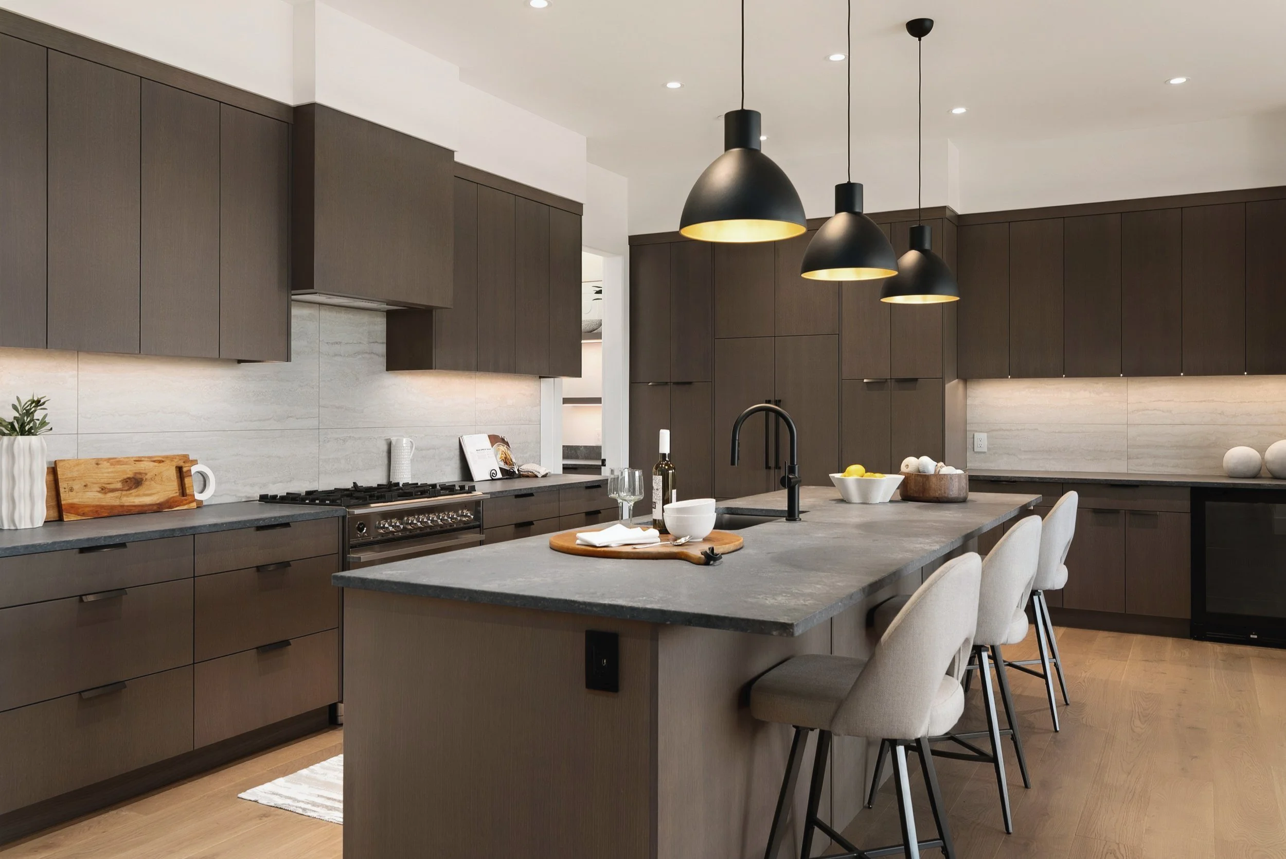 Kitchen with dark wood cabinetry, black pendants and a grey stone-look island, Terrace House, Predator Ridge