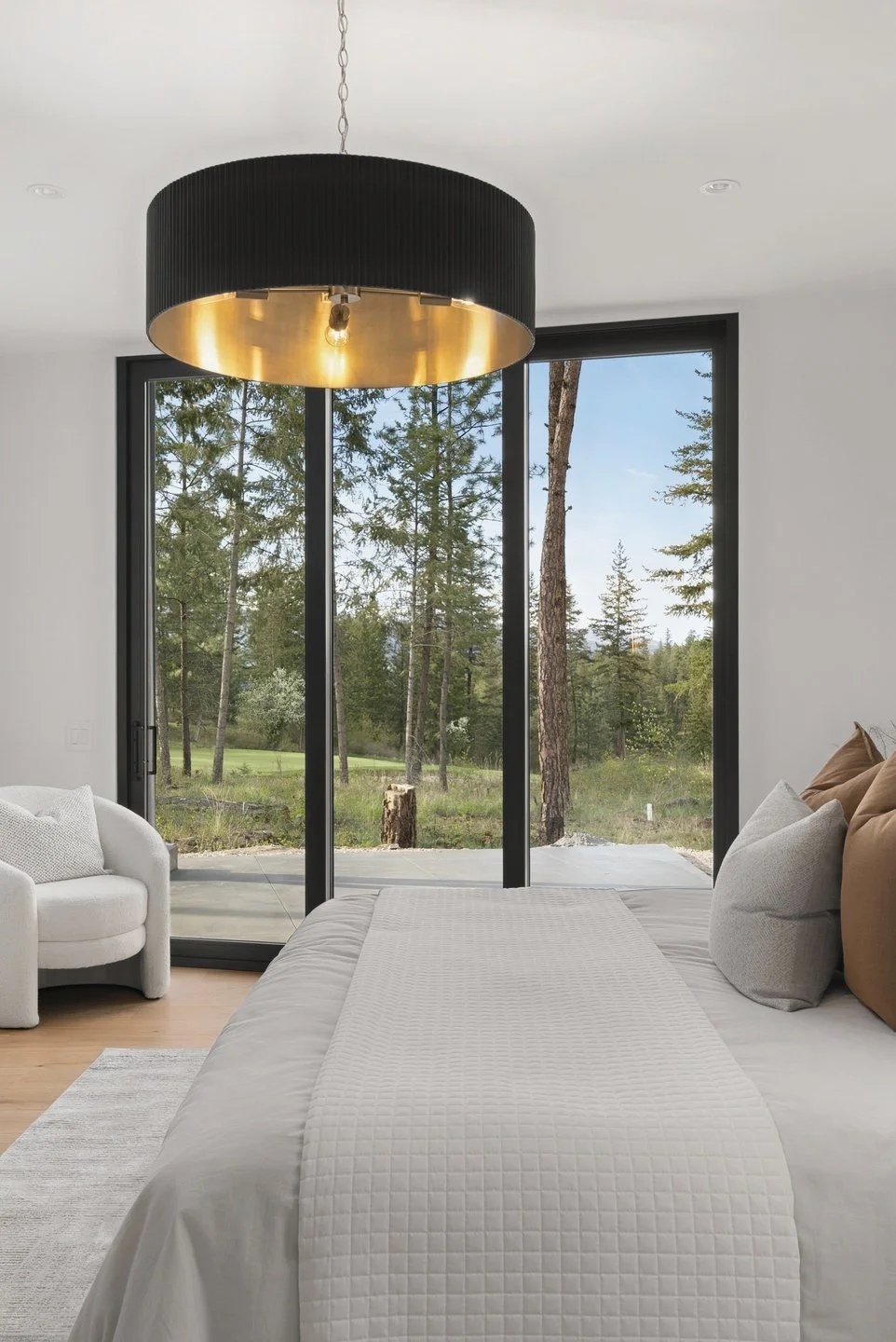 Primary bedroom looking out through floor-to-ceiling glass to the trees, Fairway Rancher, Predator Ridge