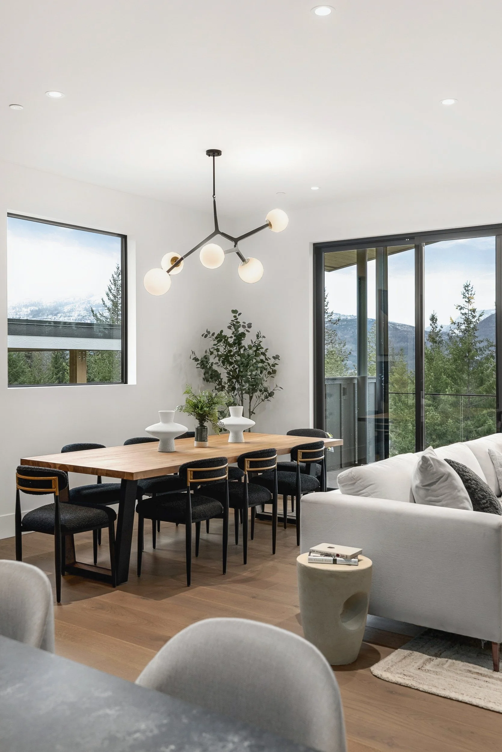 Dining table under a branch chandelier beside the windows, Terrace House, Predator Ridge