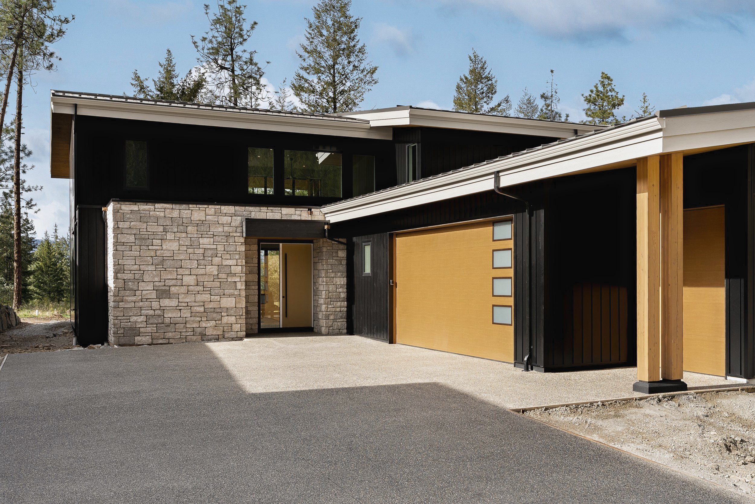 Front entry with stone, black siding and wood accents, Green View Residence, Predator Ridge