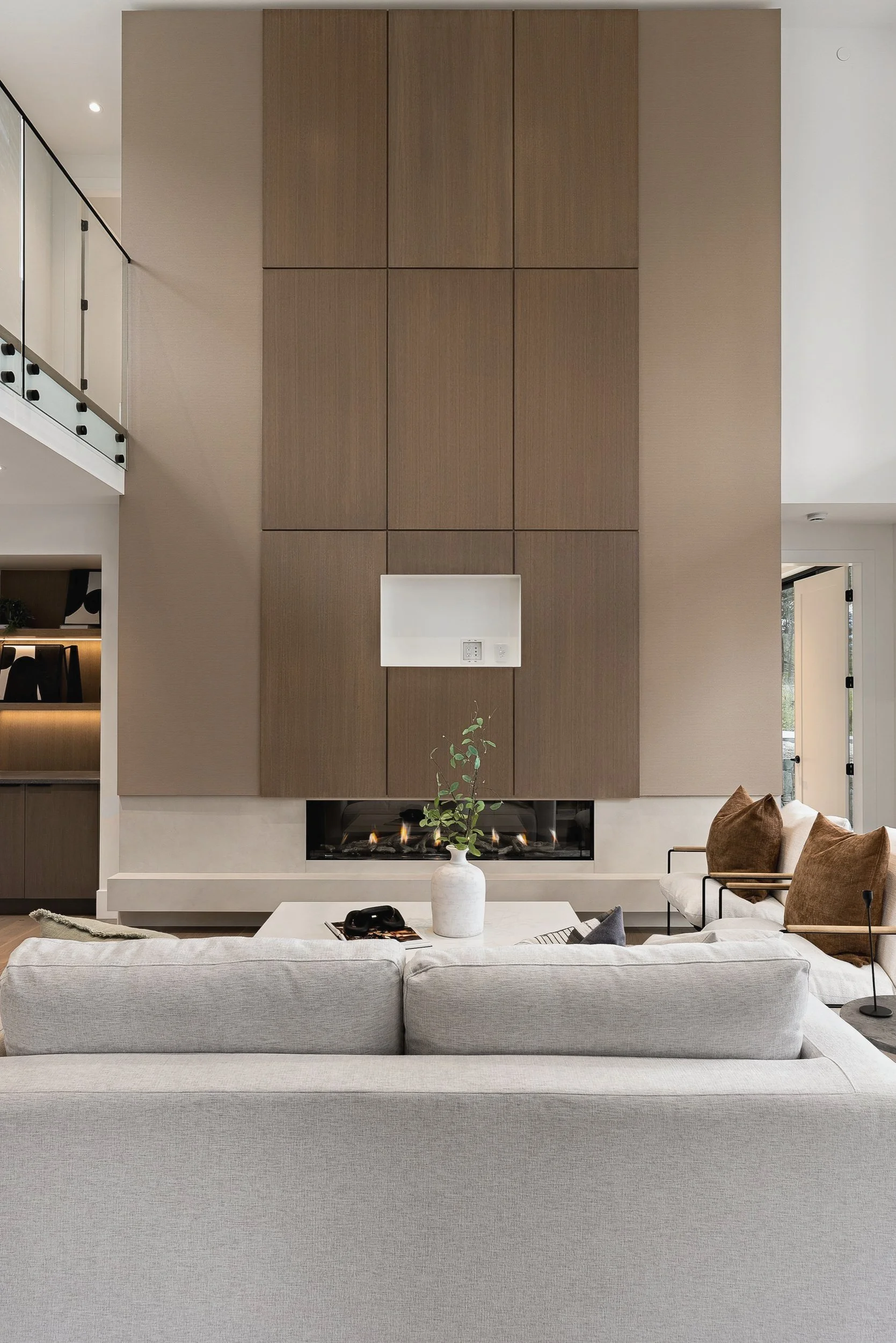 Tall wood-panelled fireplace wall beside the catwalk rail, Green View Residence, Predator Ridge