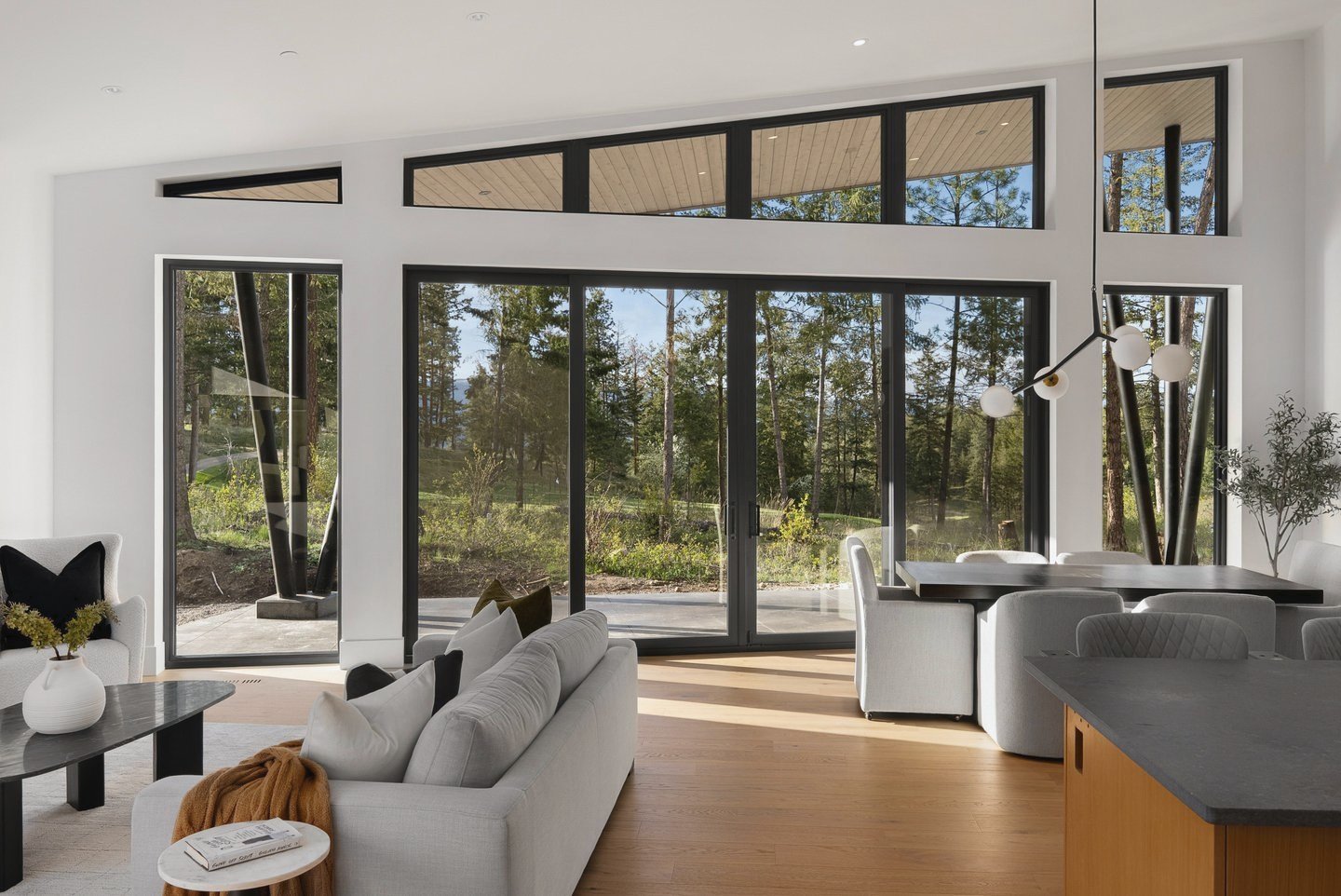 Great room with floor-to-ceiling black-framed glass facing the pines, Fairway Rancher, Predator Ridge