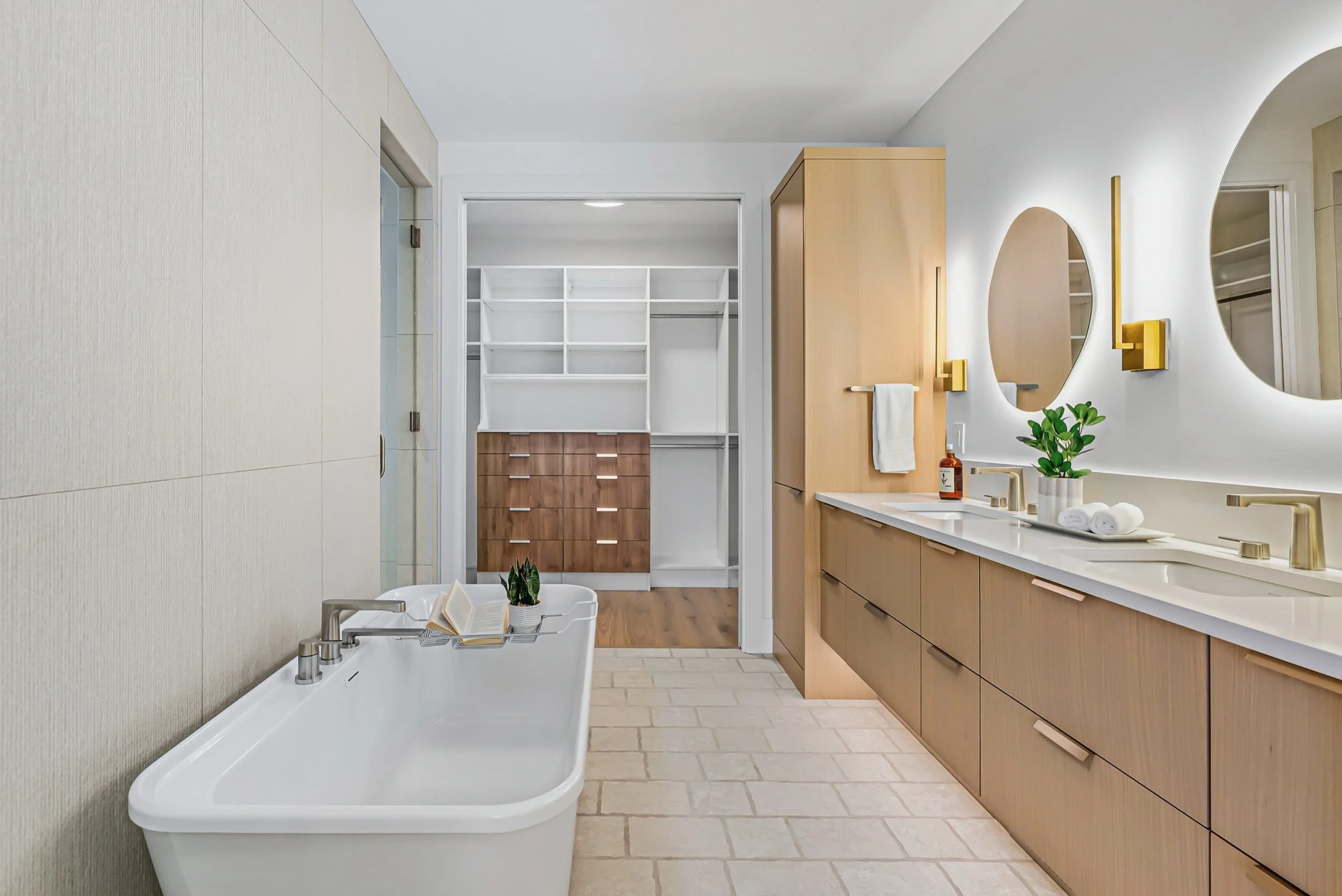 Primary ensuite with a freestanding tub, oak vanity and walk-in closet beyond, Ellison Walkout, Predator Ridge