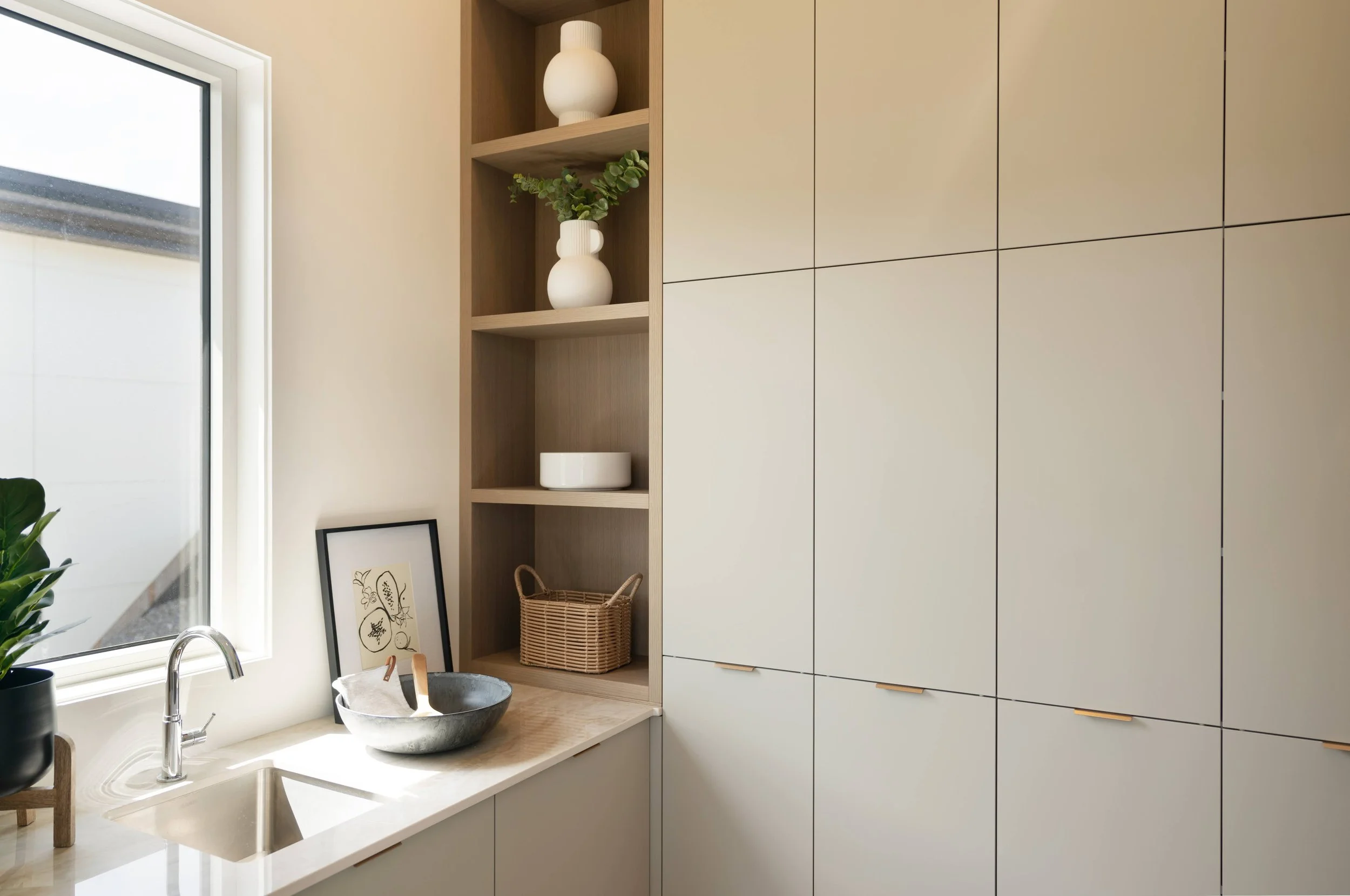 Light wood built-in cabinetry and open shelving with sink, Trailhead Showhome, Kelowna