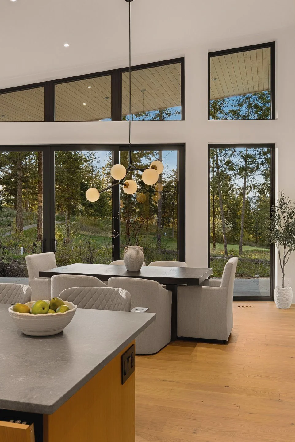 Dining table under rake windows, seen from the kitchen island, Fairway Rancher, Predator Ridge