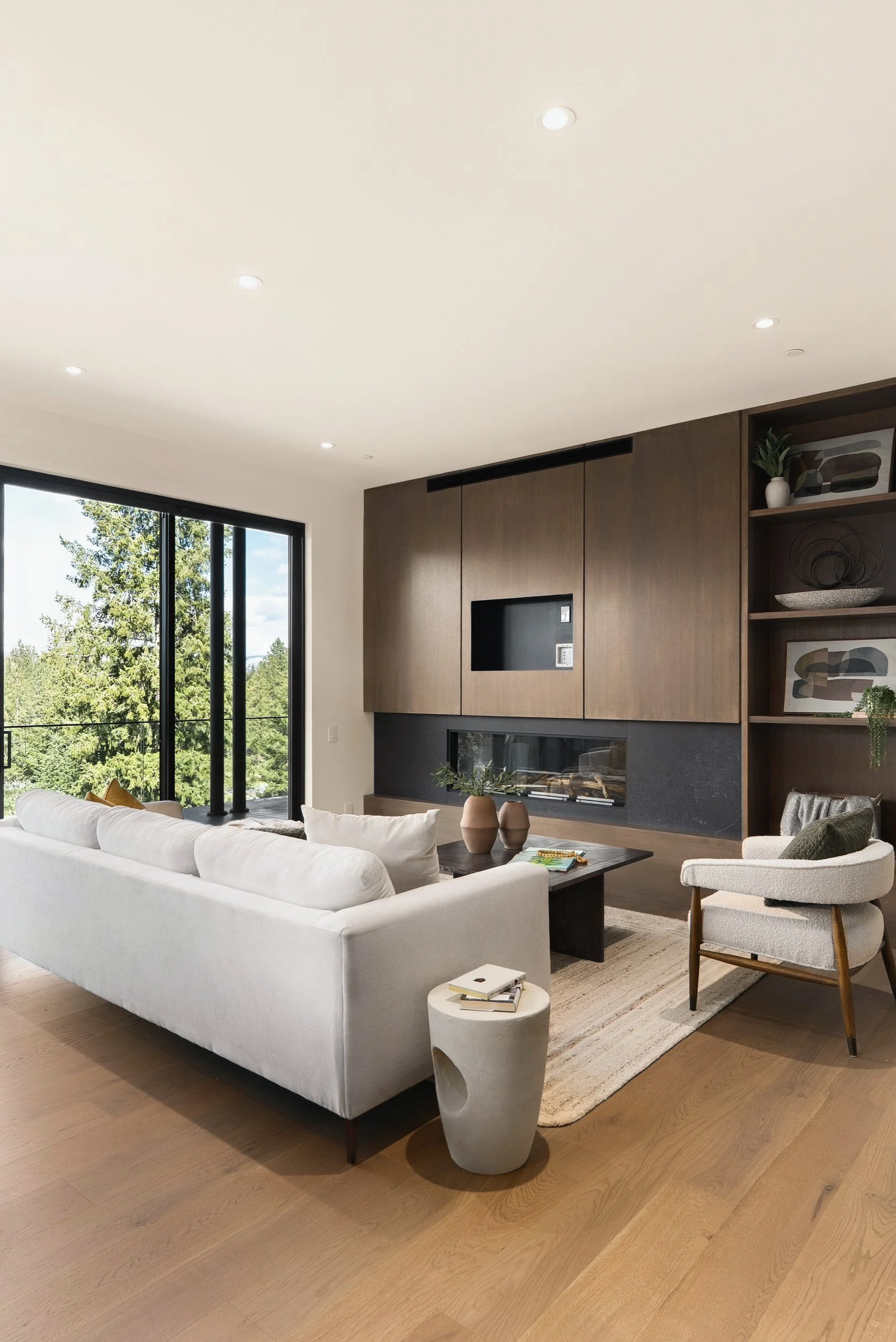 Living area with a dark wood fireplace and media wall, Terrace House, Predator Ridge