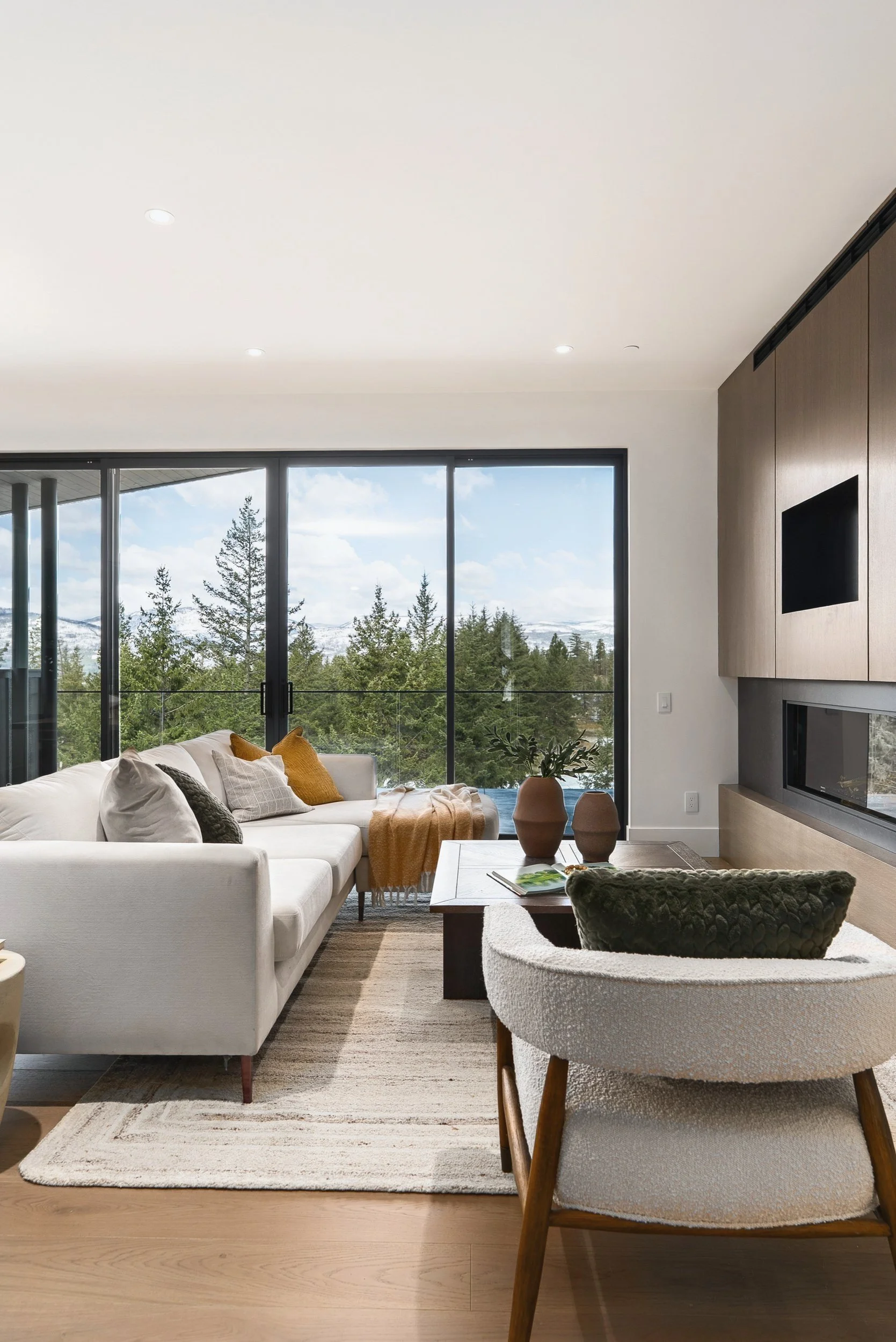 Living room with a sofa and lounge chair facing the window wall, Terrace House, Predator Ridge