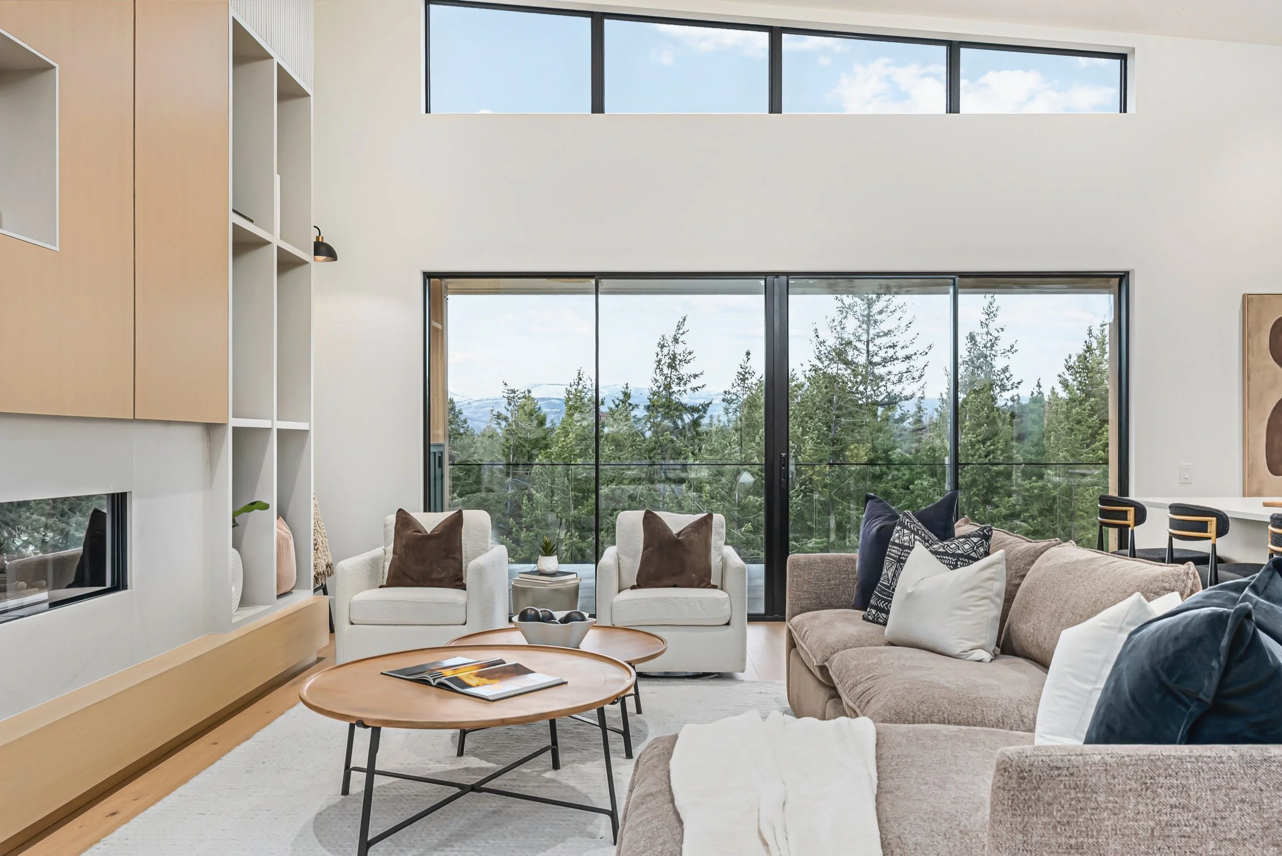 Living area with a round coffee table and sliding glass doors to the forest, Ellison Walkout, Predator Ridge
