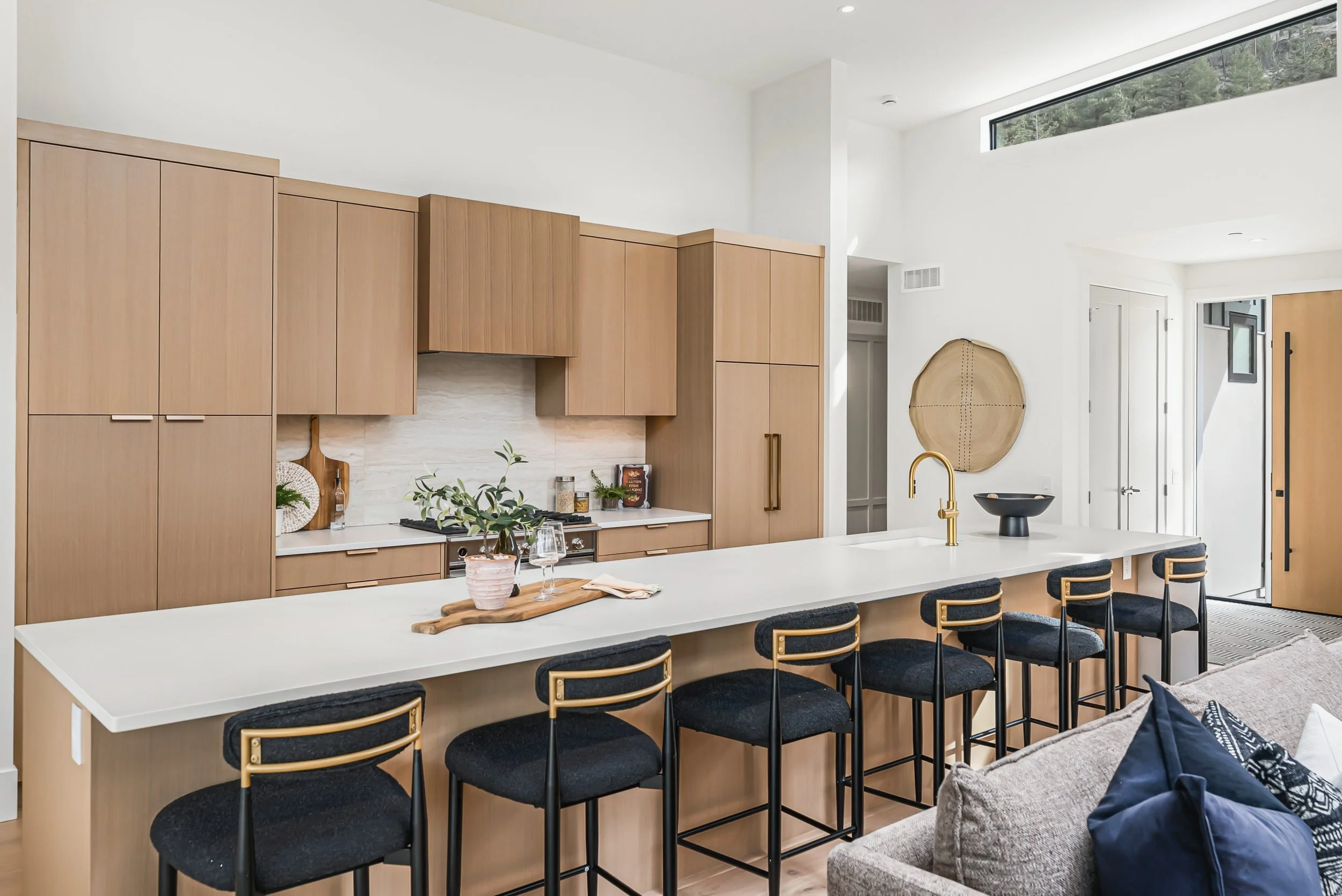 Long white island with navy stools and oak cabinetry, Ellison Walkout, Predator Ridge