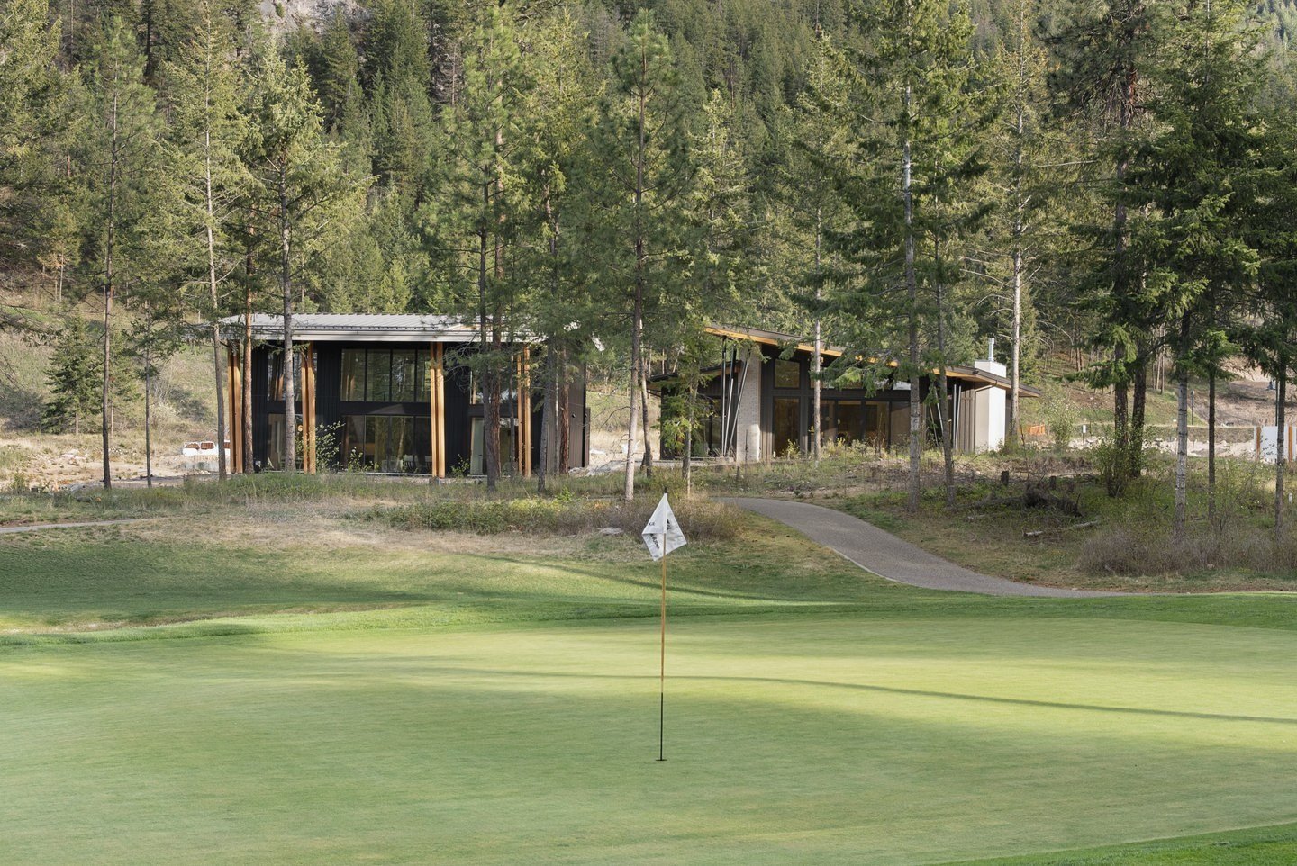 The home in the pines behind the green, seen from the golf course, Fairway Rancher, Predator Ridge